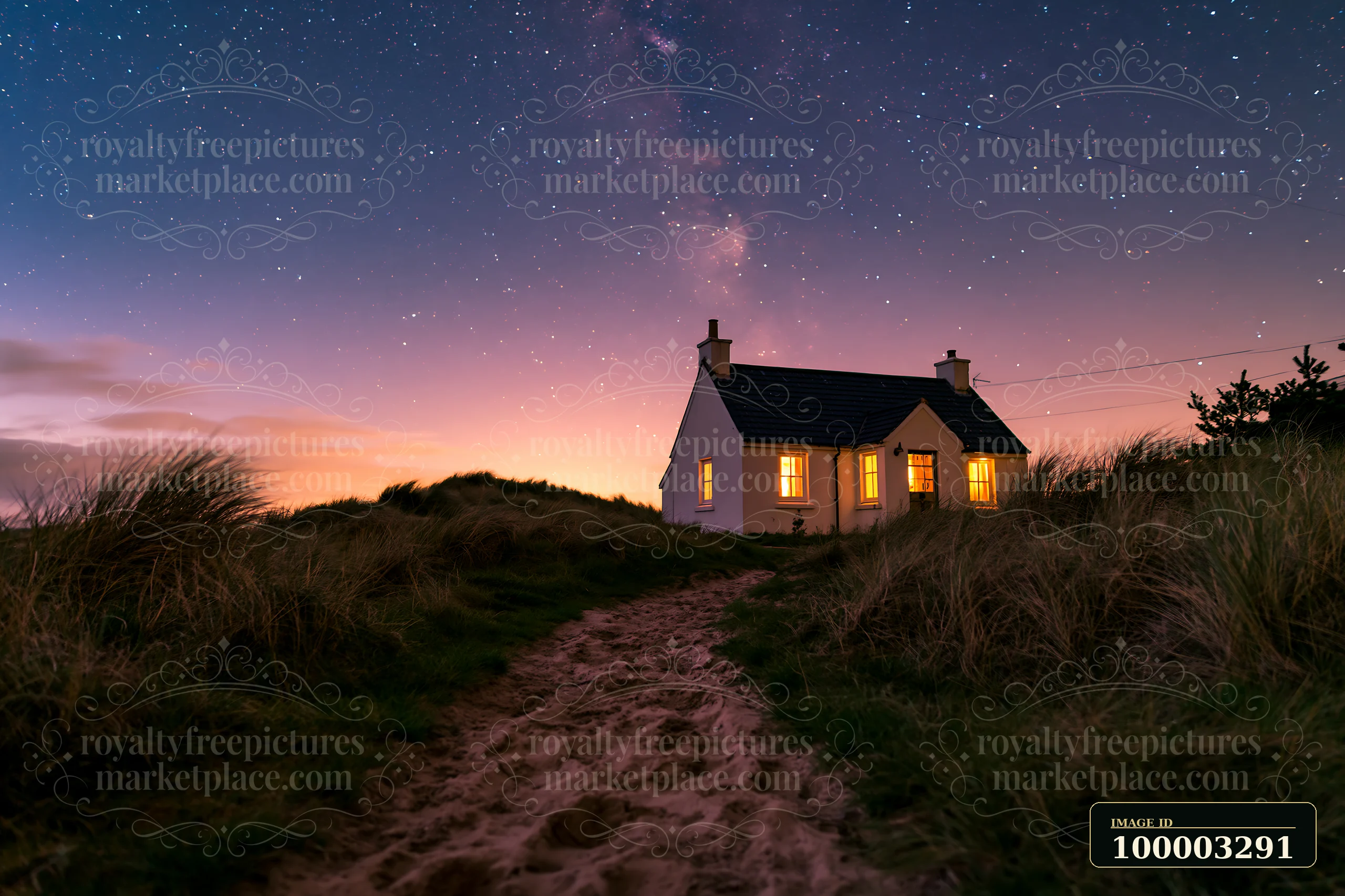 A coastal cottage under stars stands on a sandy path, illuminated by warm light from its windows.