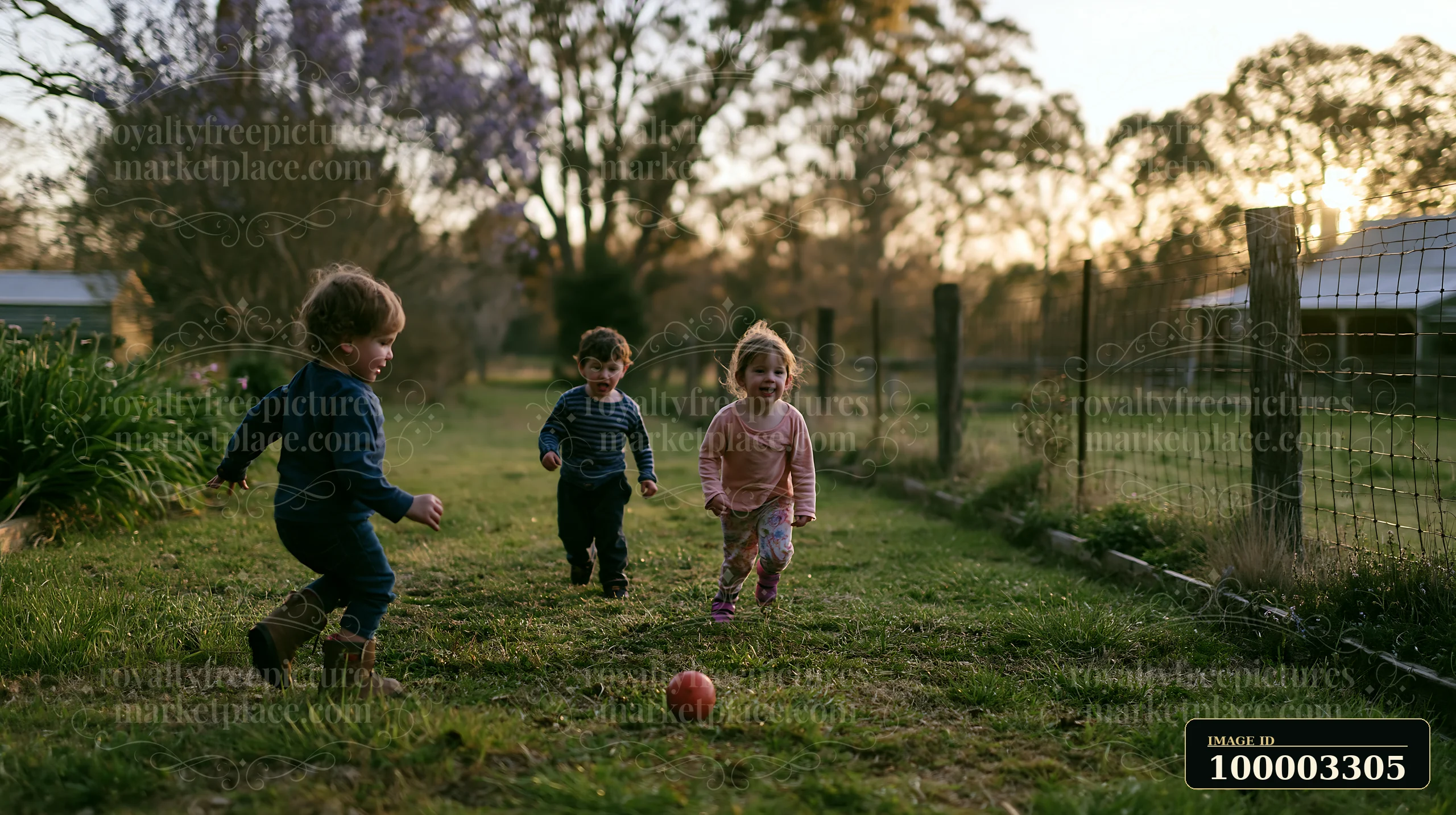 Three children run joyfully in a farmhouse garden as the sun sets.