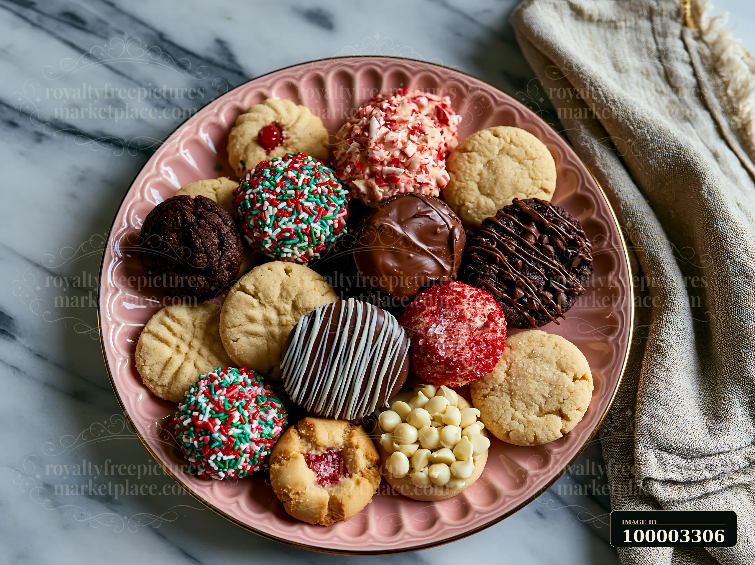 Christmas cookies are arranged on a pink plate, placed on a marble kitchen countertop.