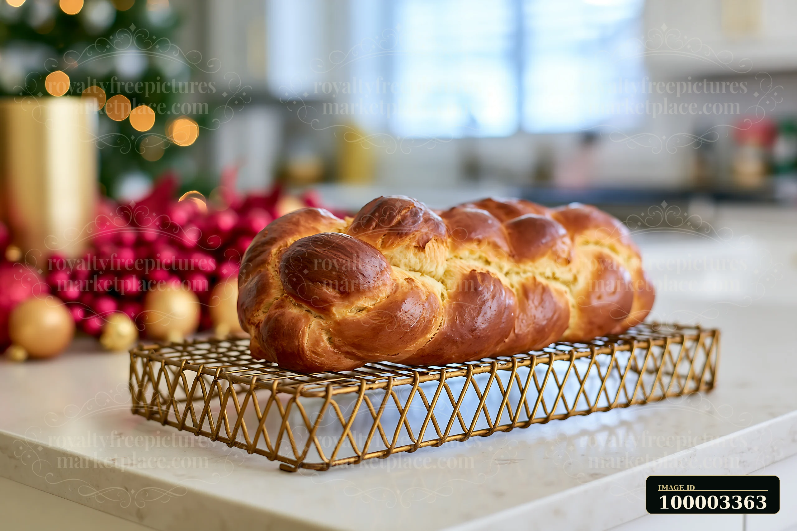 A braided loaf of bread rests on a gold wire rack in a modern festive kitchen.