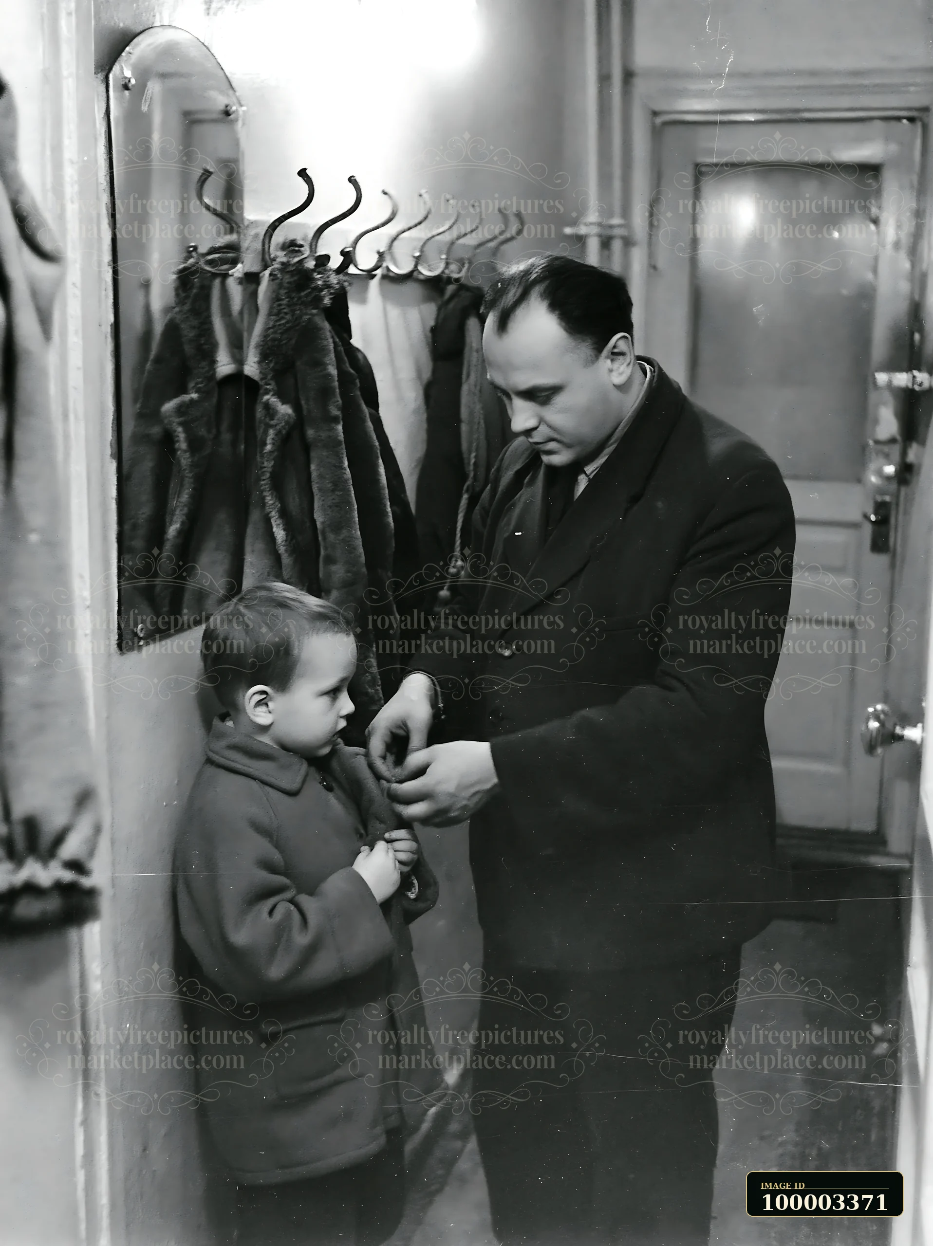A man assists his young son in putting on a coat in a hallway of a Soviet apartment.
