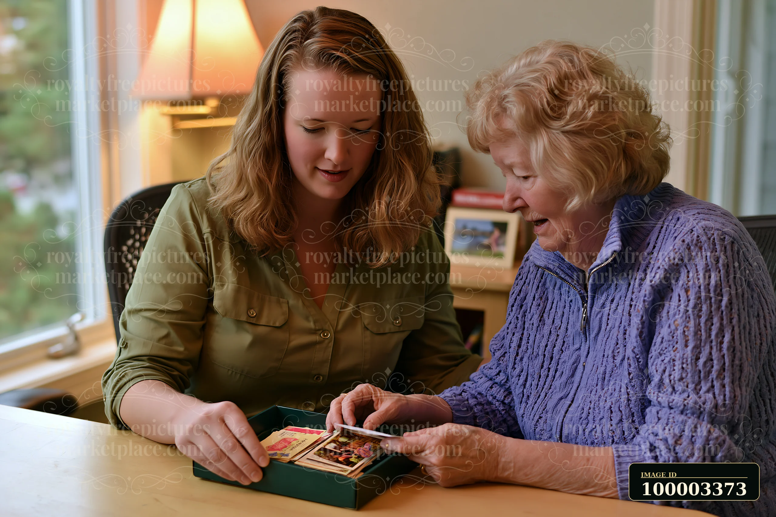 A caregiver providing companionship to senior dementia patient sorts through old photographs at home.