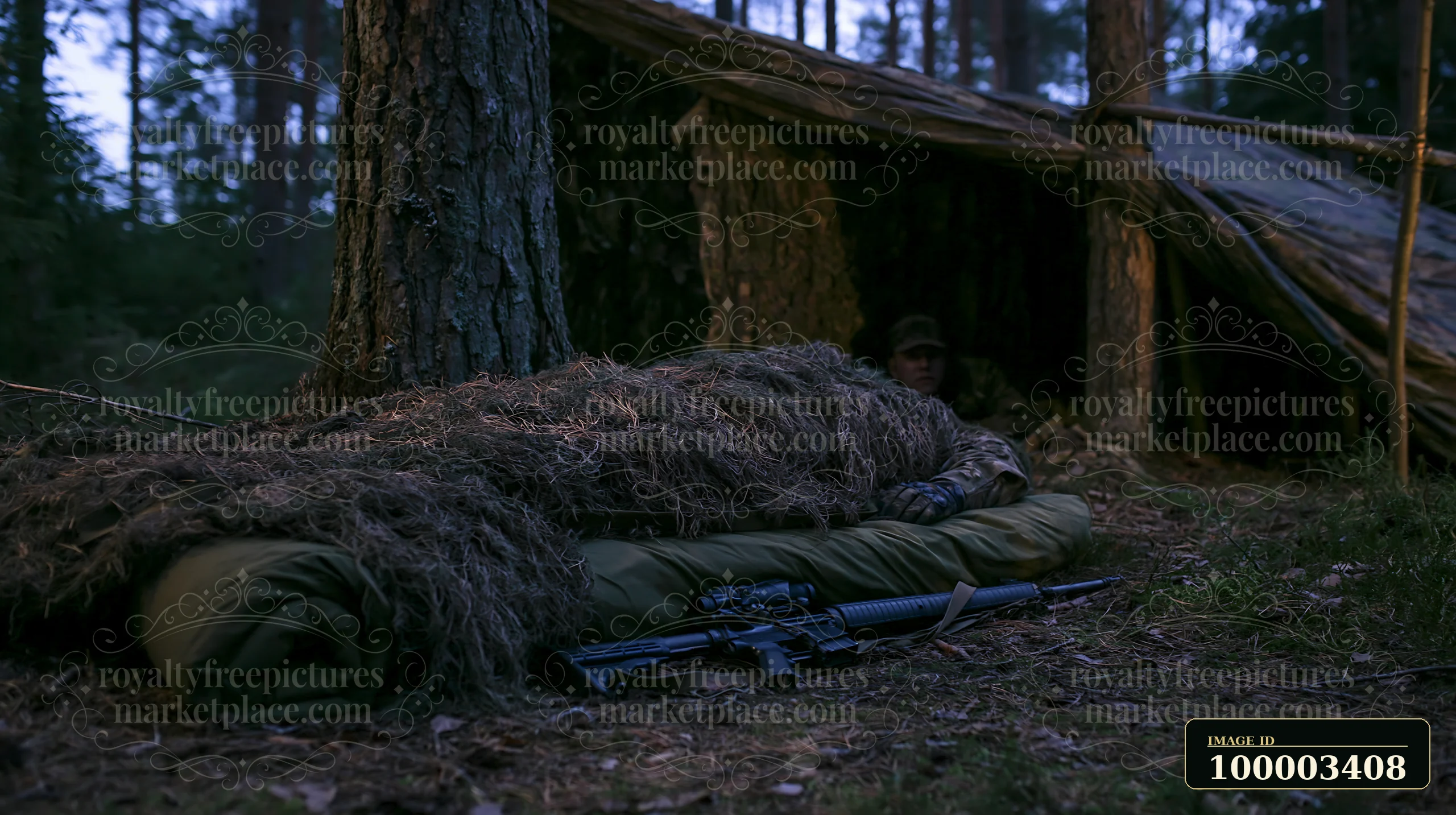 A soldier under camouflage netting rests near a makeshift shelter in a dense forest.