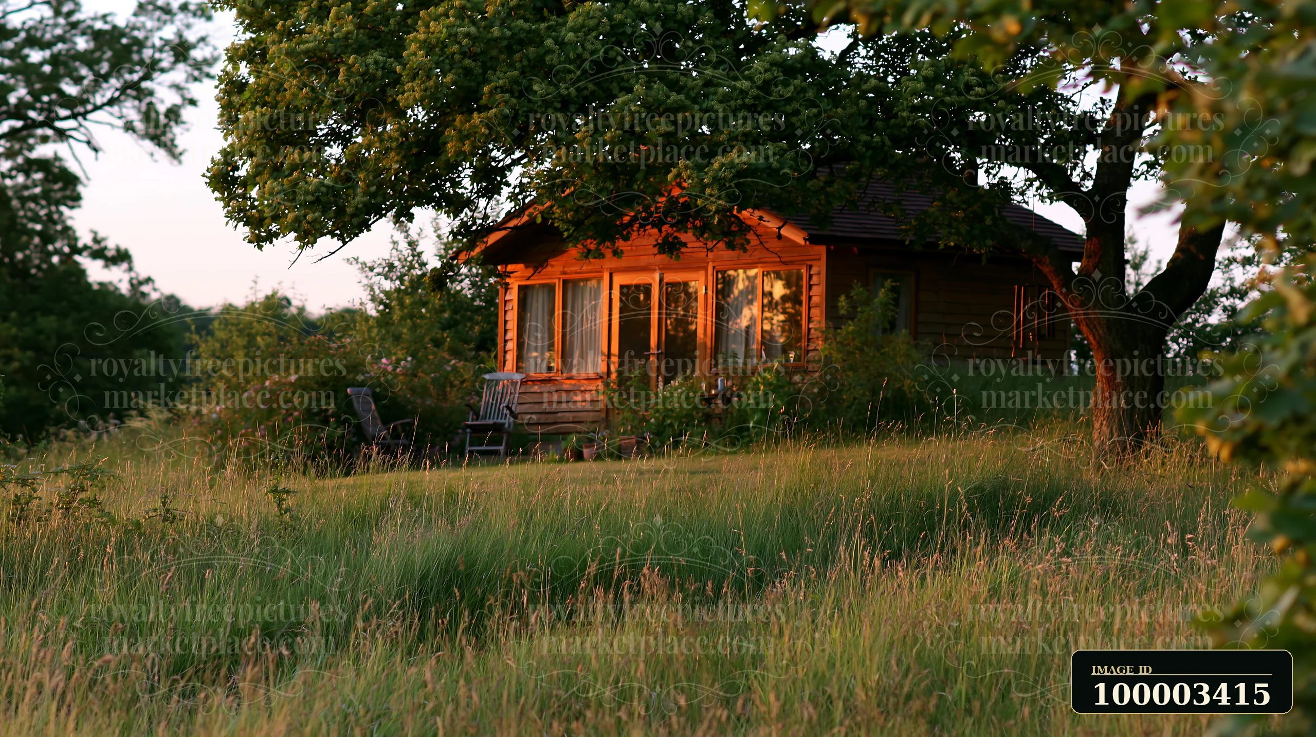 The scene shows an empty garden room with large windows, surrounded by green grass and trees, as the sun sets.