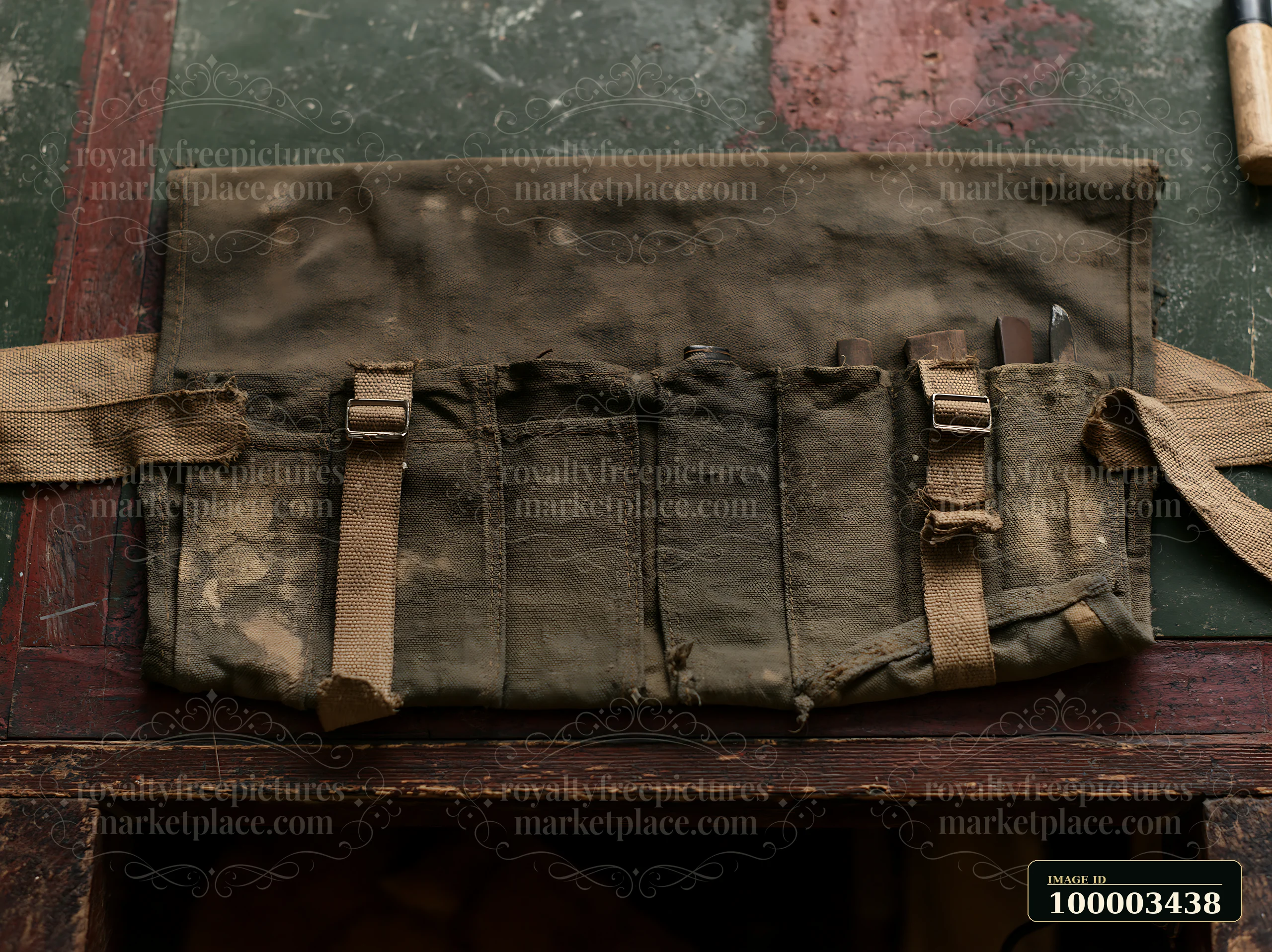 A worn fabric with faded blotches lies flat on a textured surface.