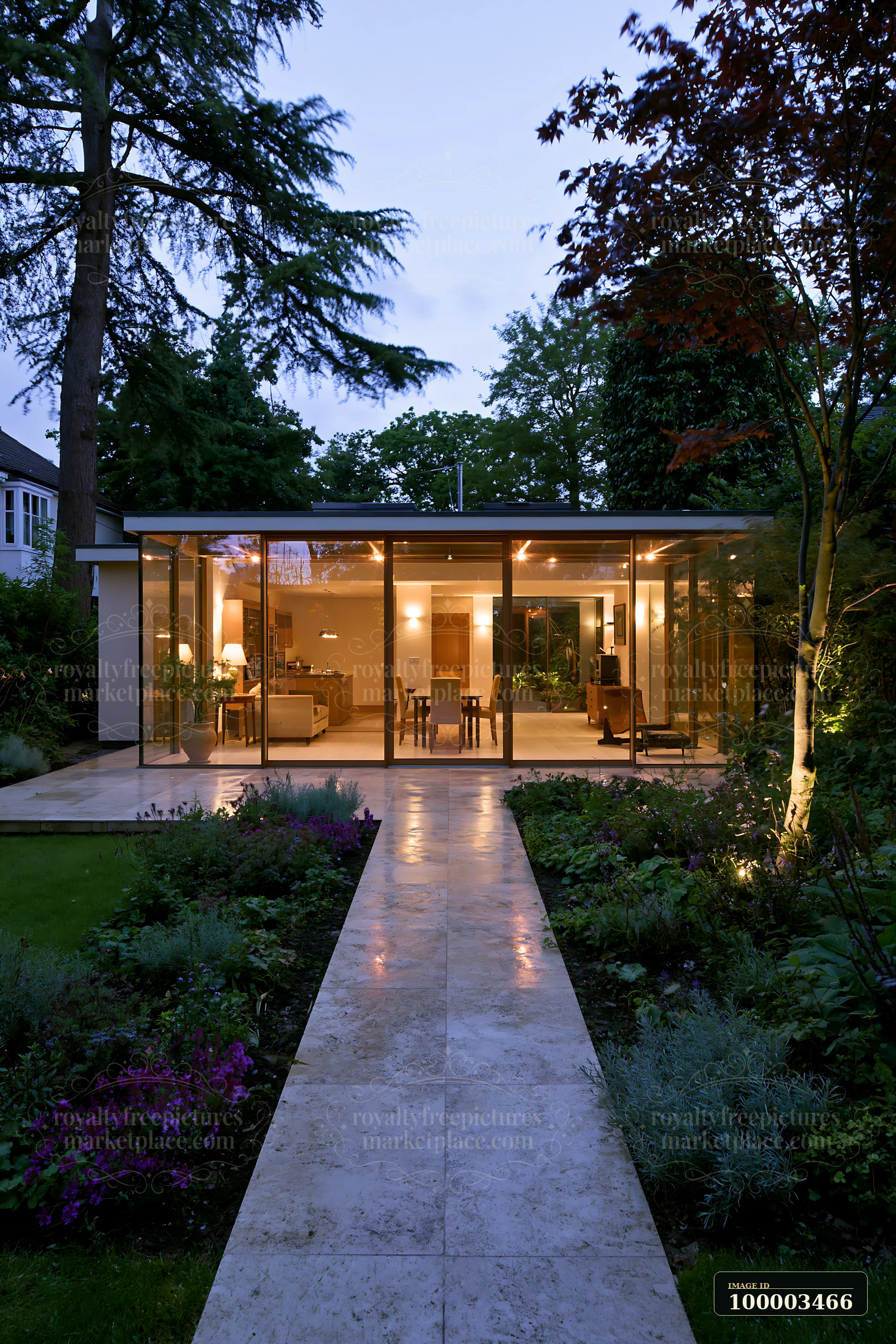 A modern empty garden house with glowing glass walls stands in a peaceful setting.
