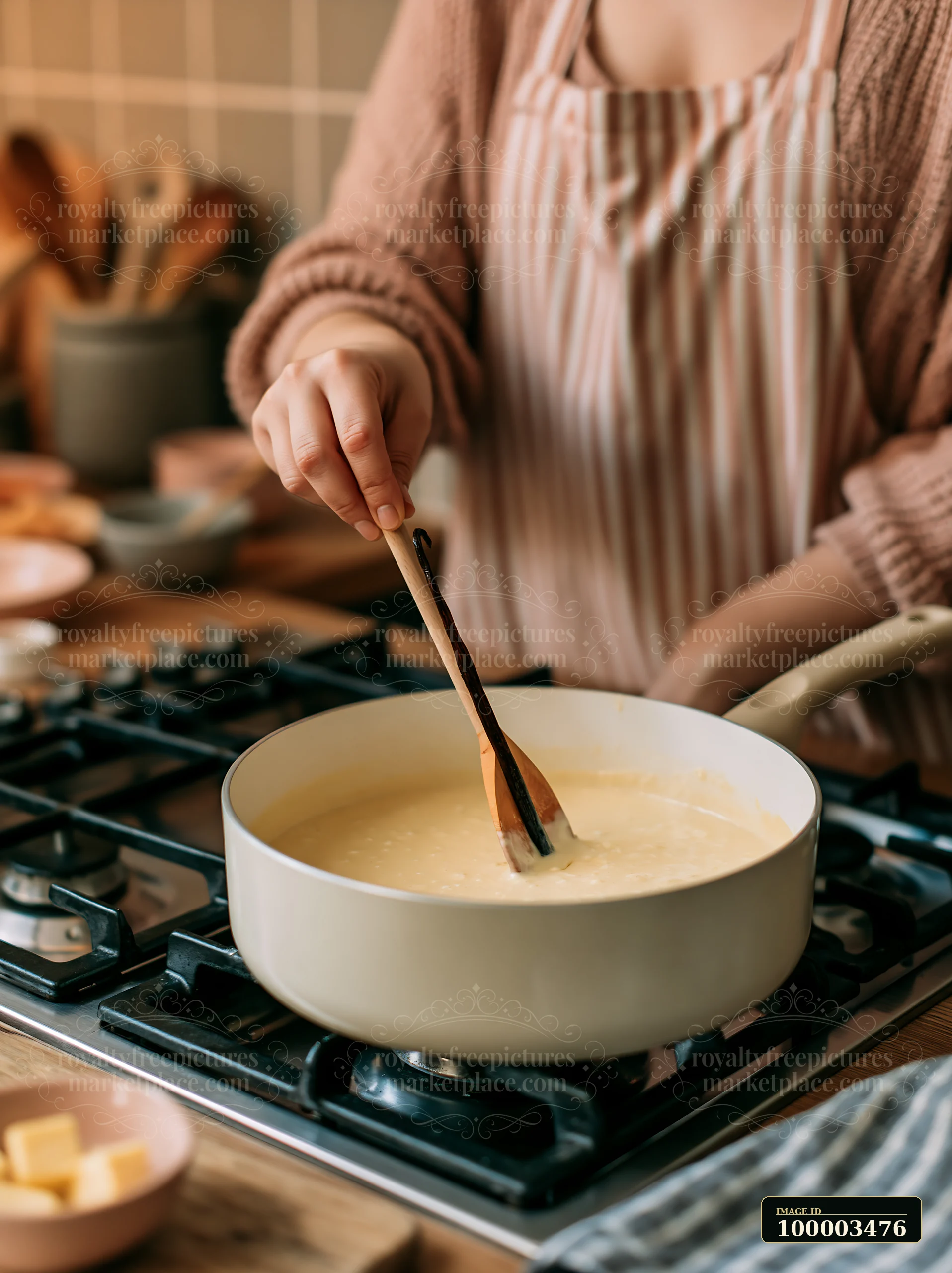 A person stirs a creamy mixture in a pot on the stove, surrounded by kitchen tools and ingredients.