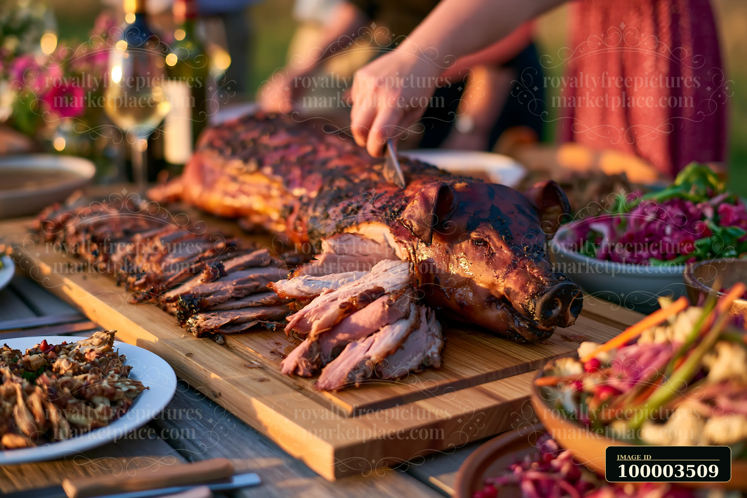 A whole roasted pig is being sliced at a rustic outdoor feast.