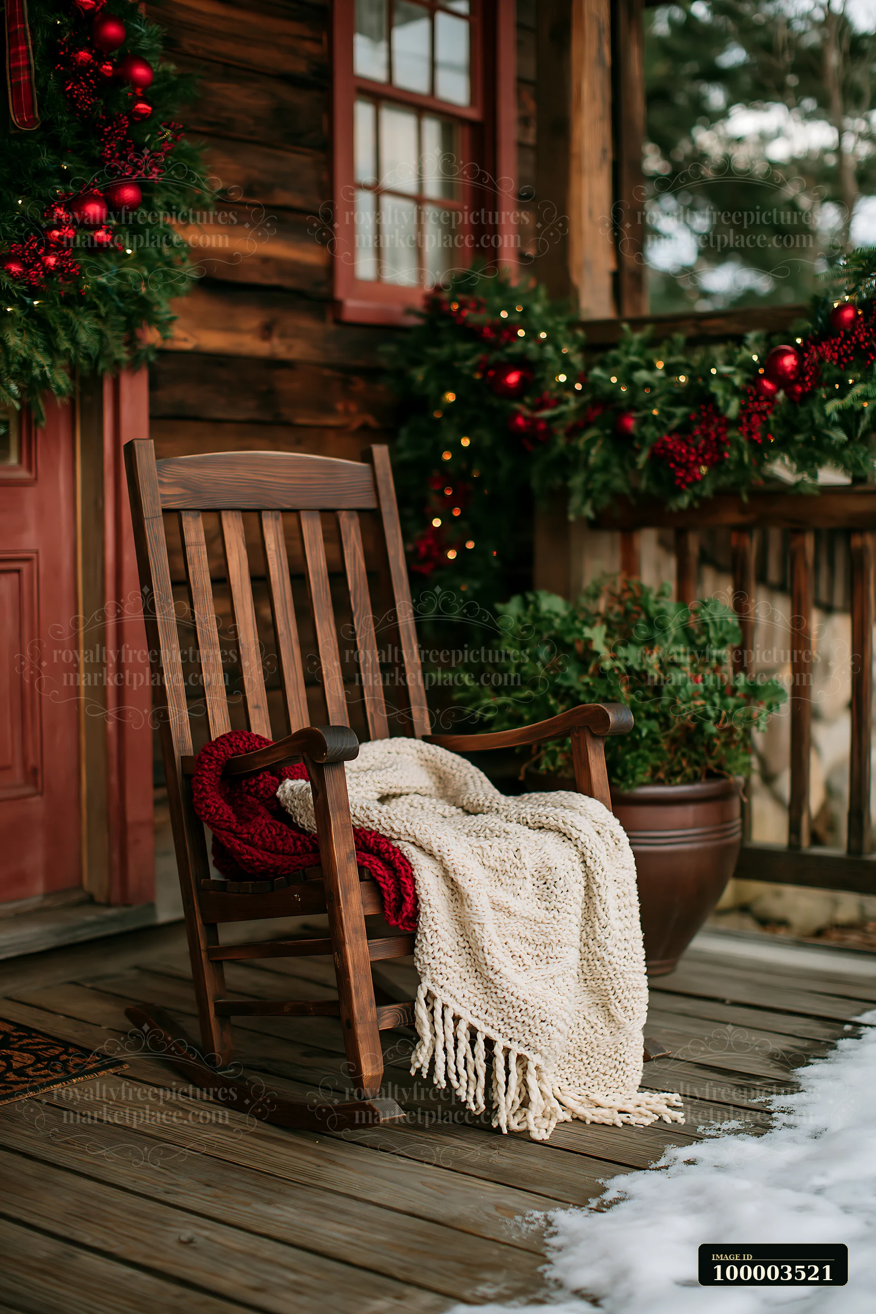 A rustic cottage porch features green garlands and red ornaments, with a rocking chair draped in a cozy blanket, inviting visitors during the holiday season.