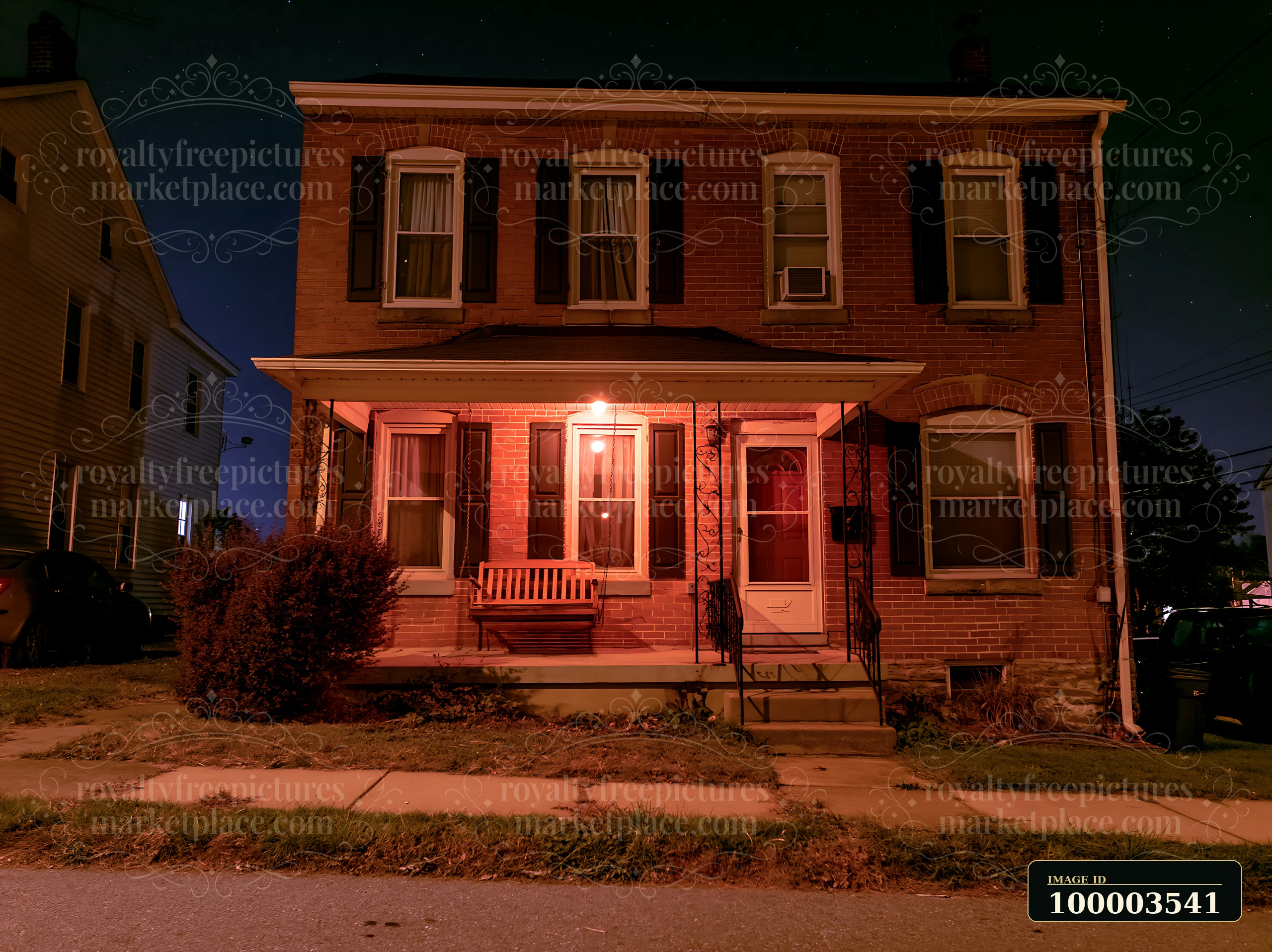 A house features a porch swing beside the front door, set against a starry night sky.