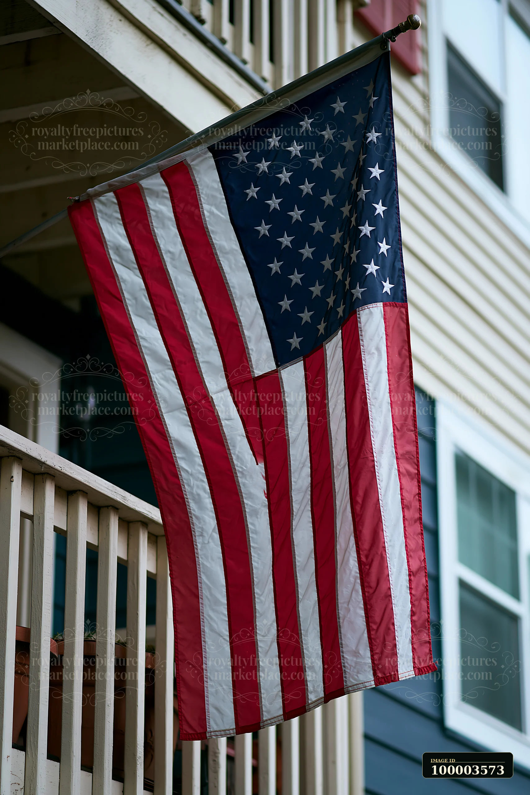 An American flag is displayed on a balcony of an apartment building.