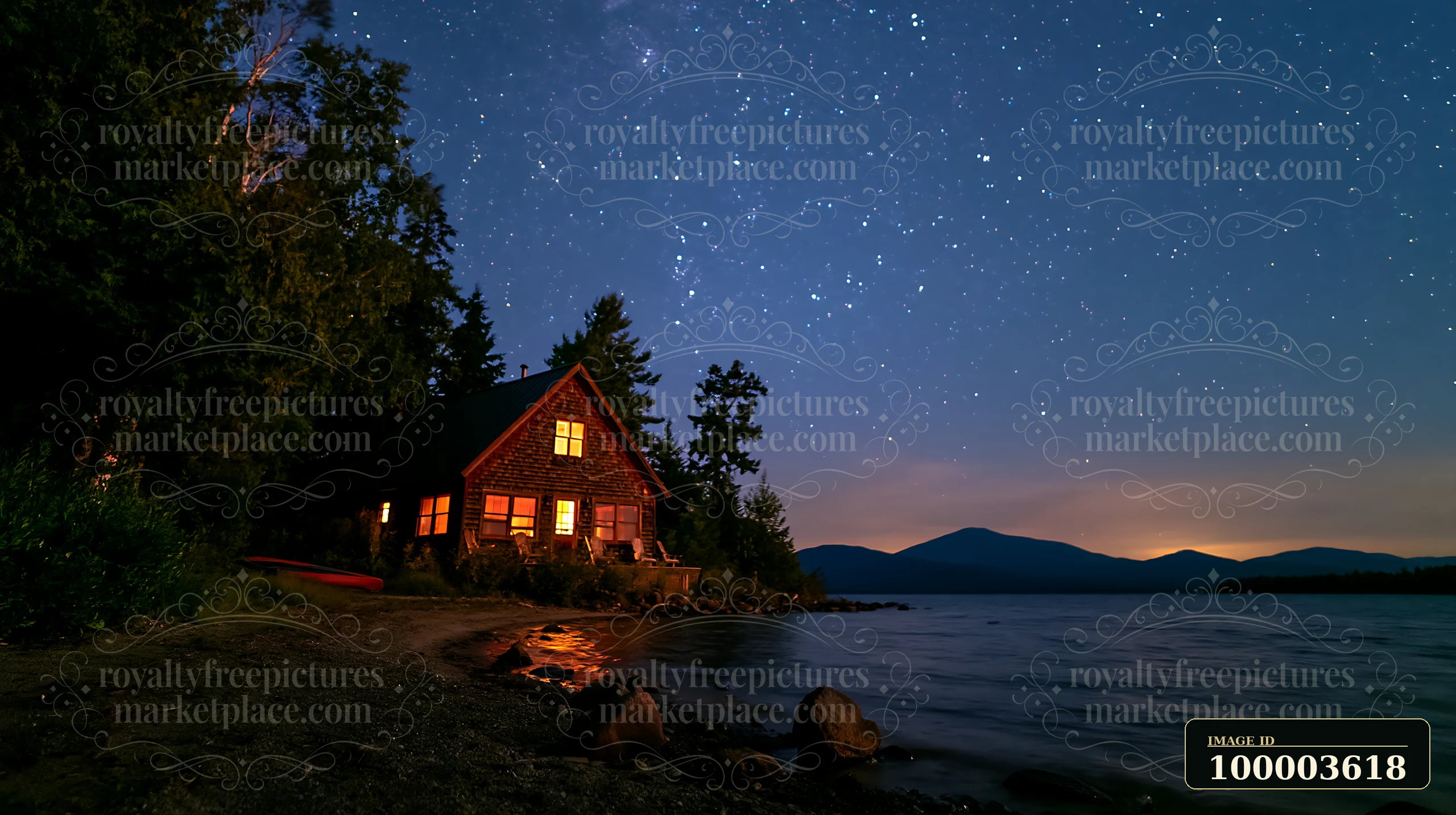 A wooden cabin sits by the water, with lights glowing warmly inside.