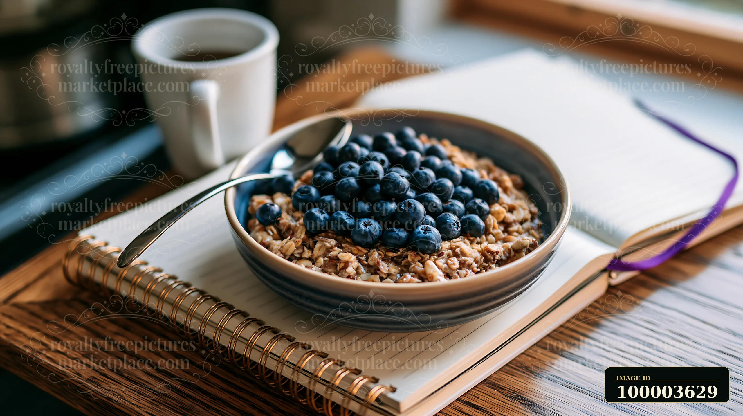 Muesli topped with blueberries sits on a plate beside coffee and a notebook on a wooden table.