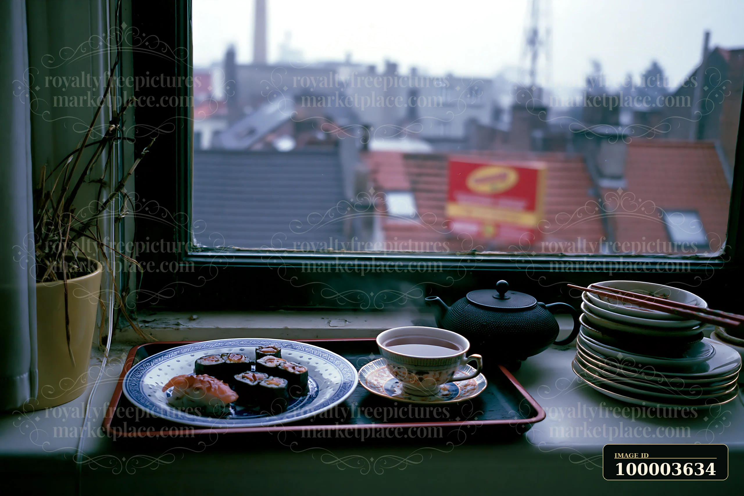 Sushi and tea sit on a tray beside a teapot on a windowsill overlooking a softly blurred city.