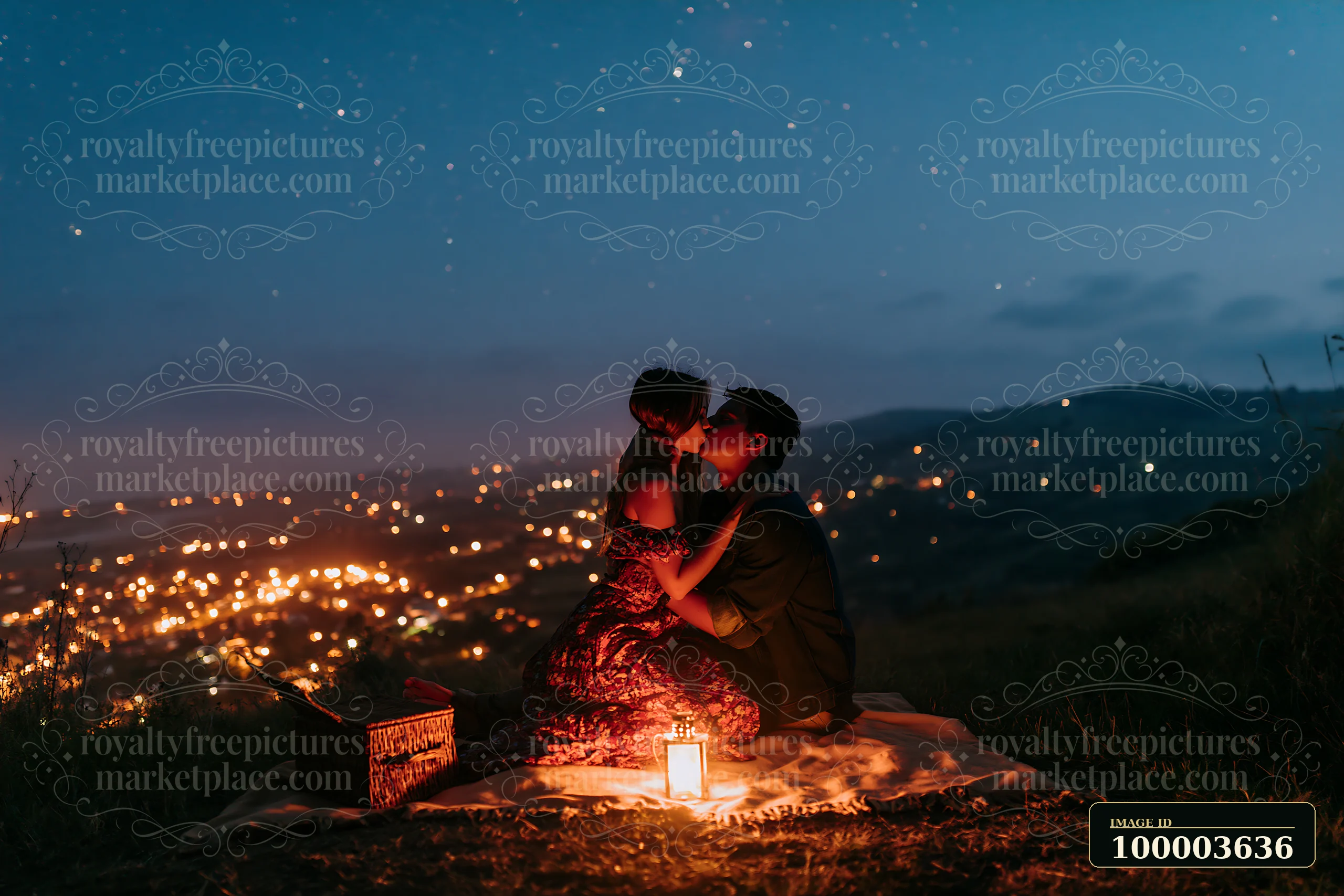 A couple kisses while sitting on a blanket under a starry sky, enjoying the beautiful view of lights from a nearby town.