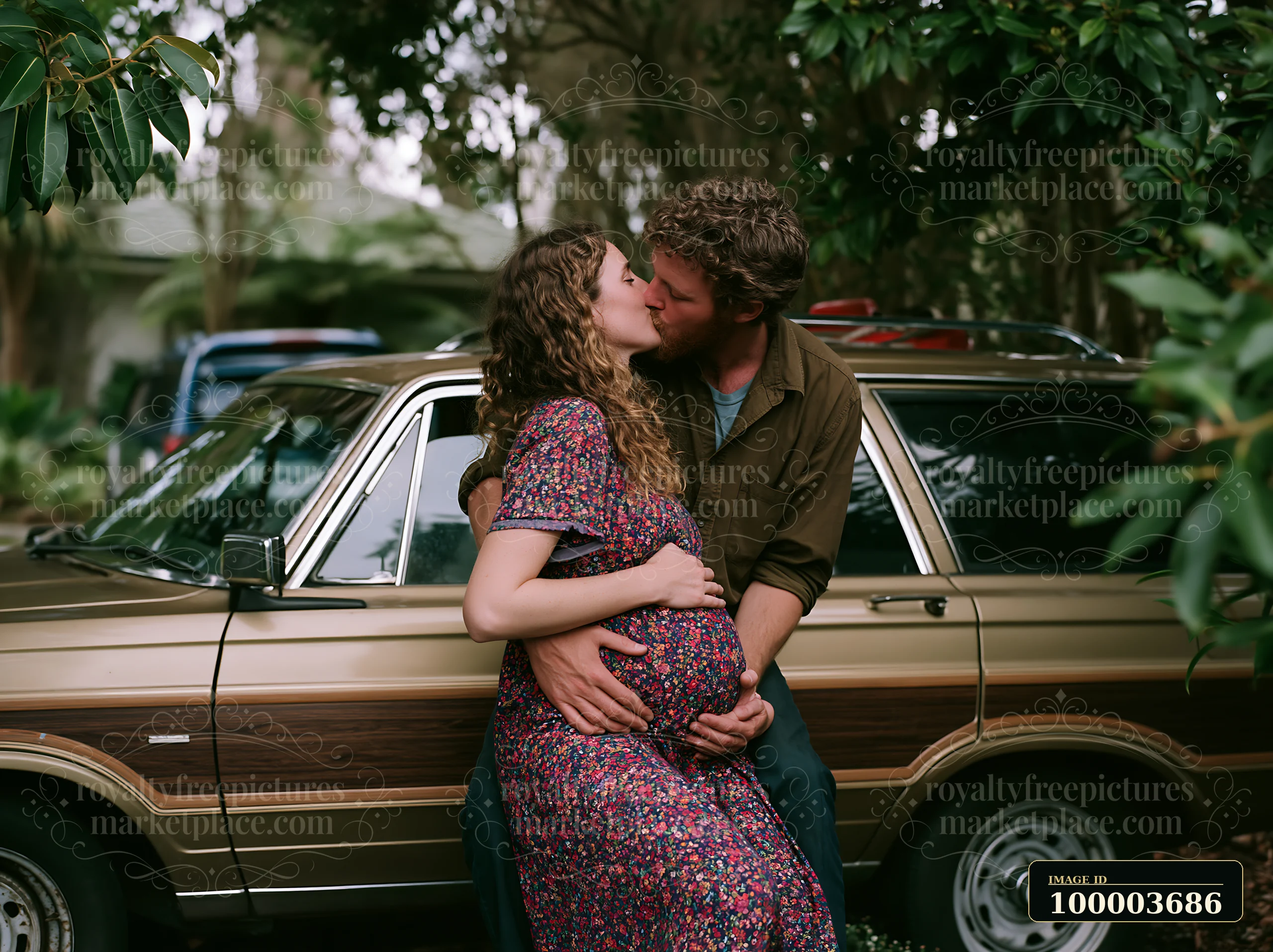 Couple kissing beside a vintage station wagon surrounded by lush garden foliage.