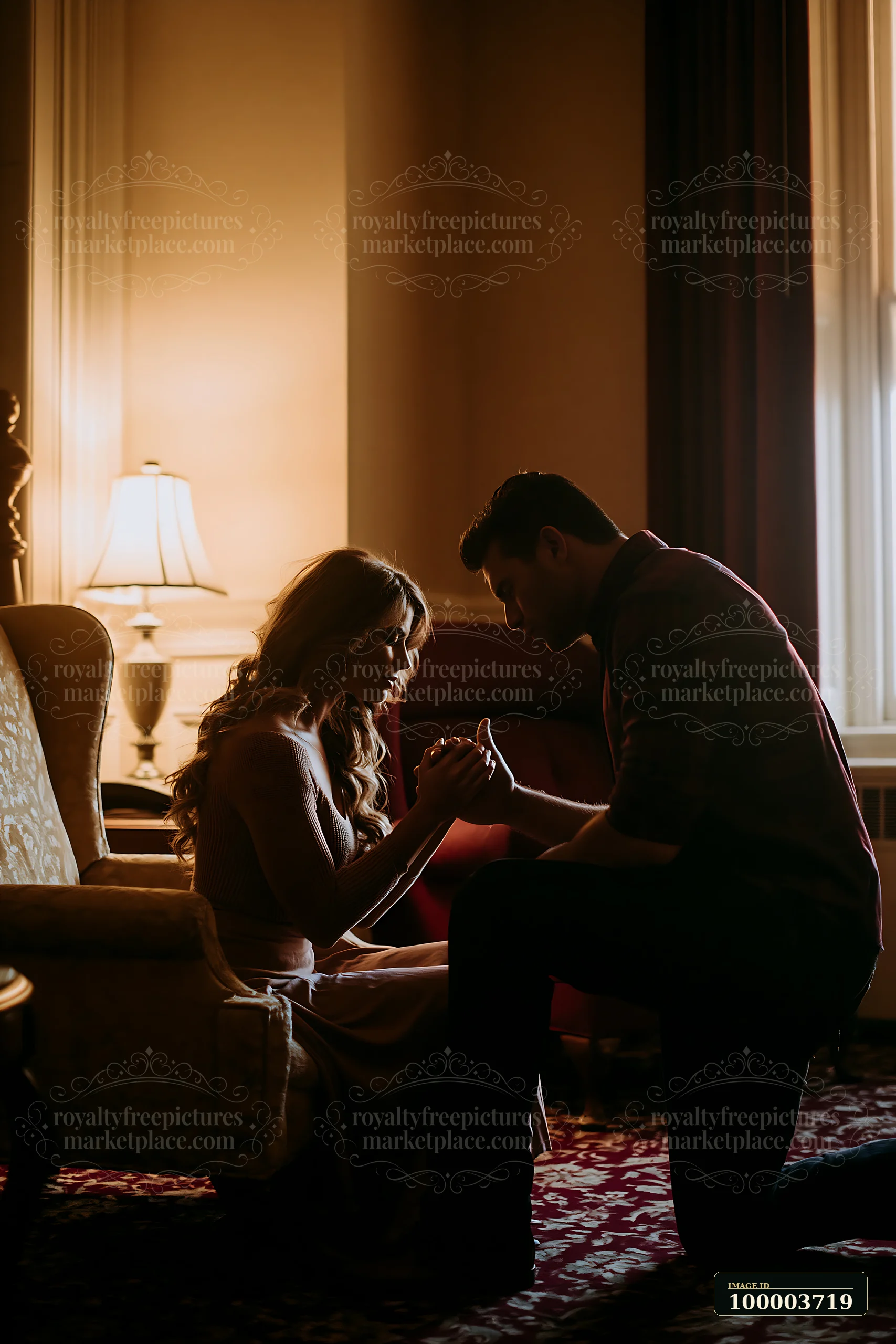 Man kneels to kiss a seated woman's hand in a warmly lit living room.