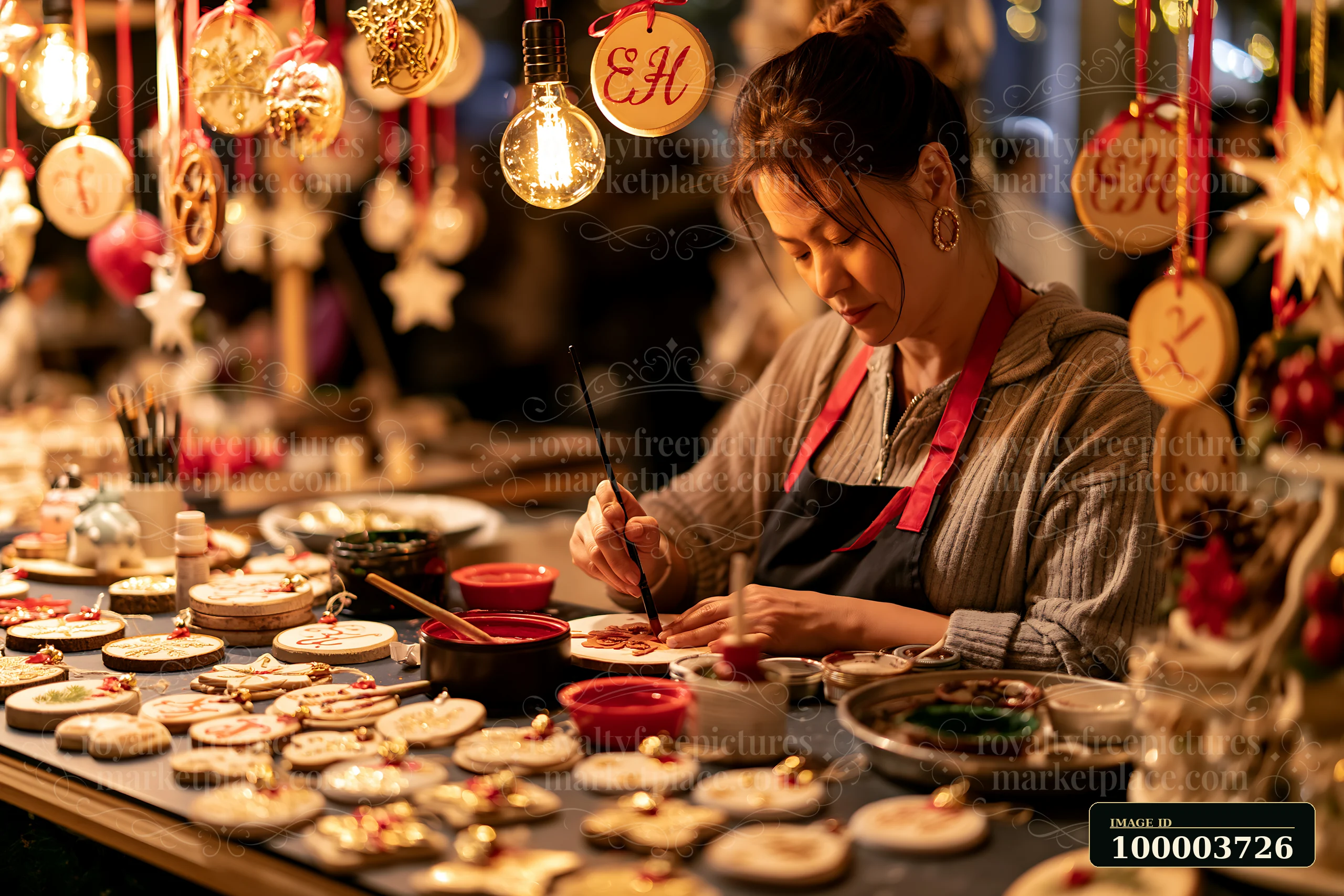 A woman crafts handmade ornaments at a festive market stall during a holiday event.