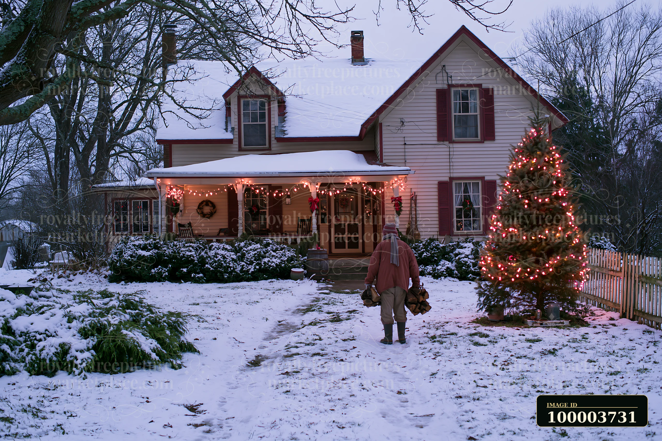A snowy country house features Christmas lights and a person walking towards it while carrying wood.