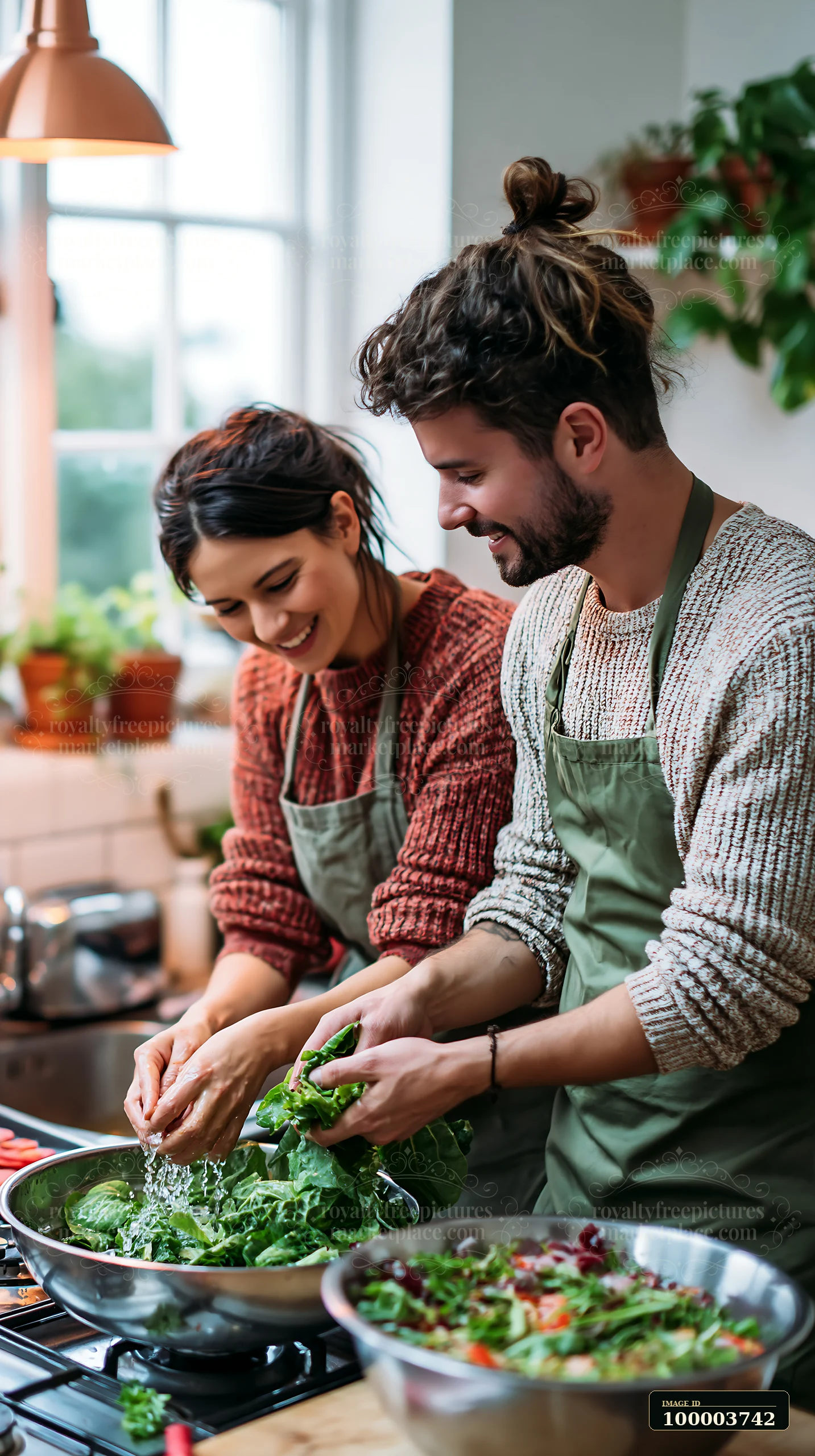 Couple washes leafy greens together beside bowls of salad in a bright kitchen.