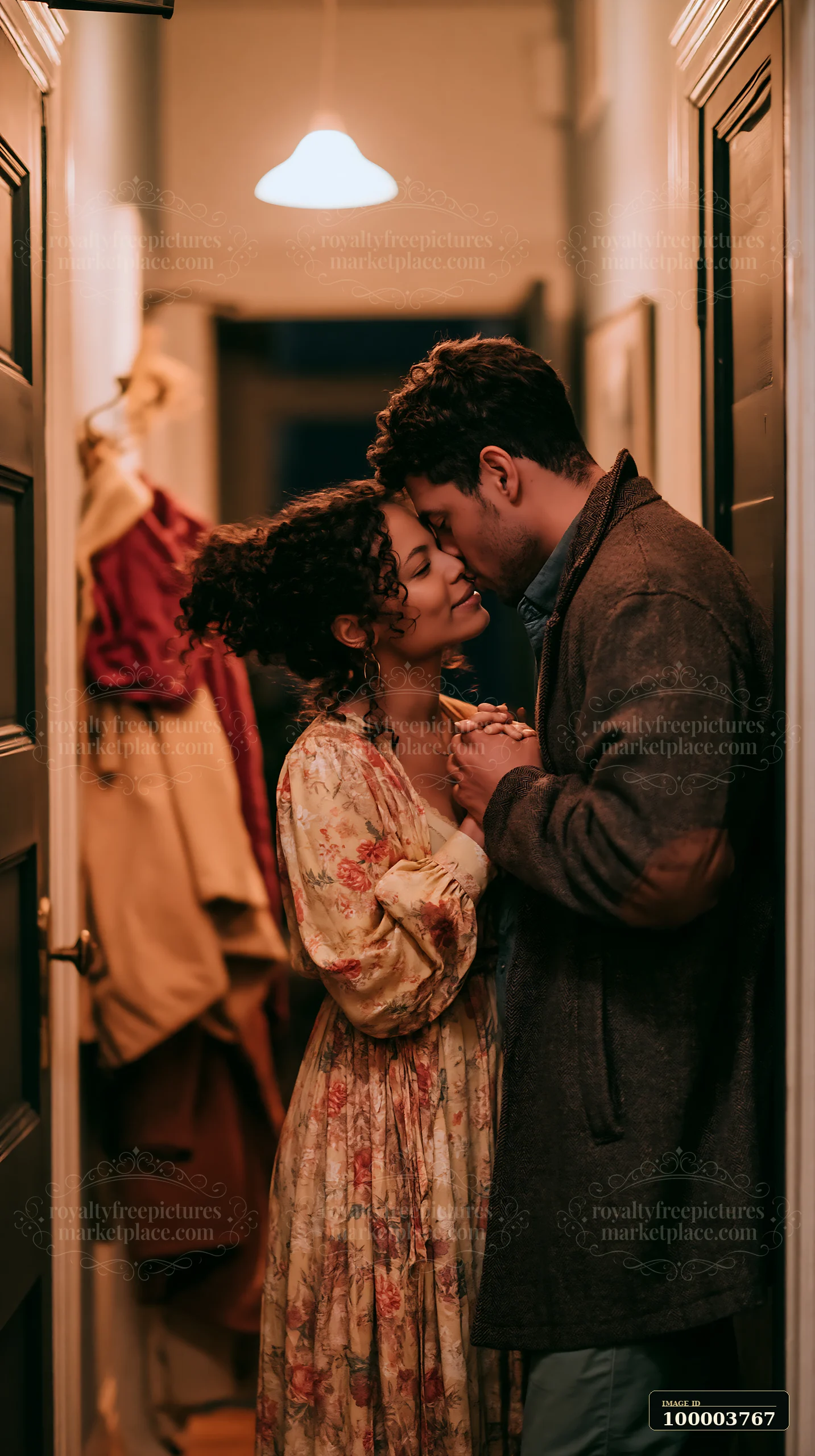 A couple shares a gentle kiss in a hallway surrounded by clothing.