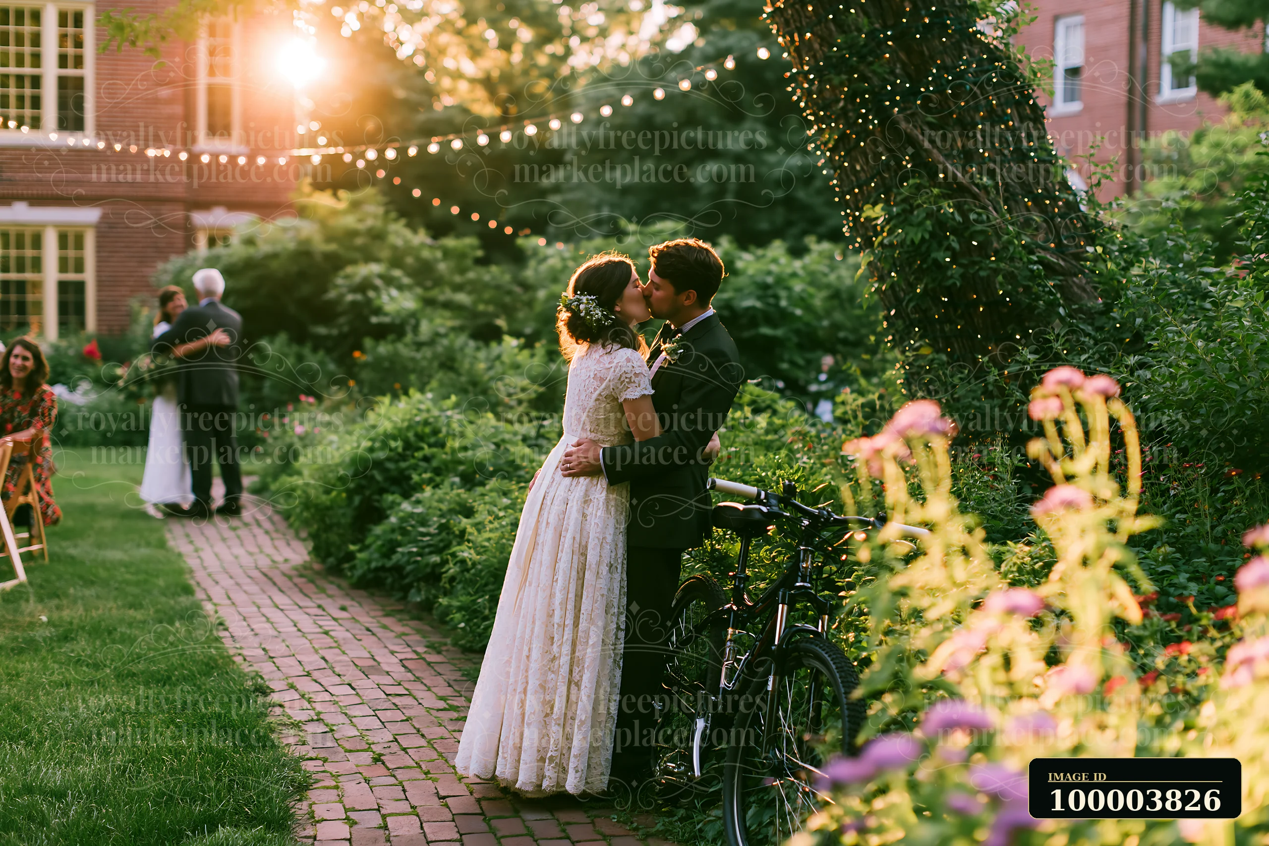 Bride and groom kiss in a flower-filled garden after their wedding ceremony beneath glowing string lights.