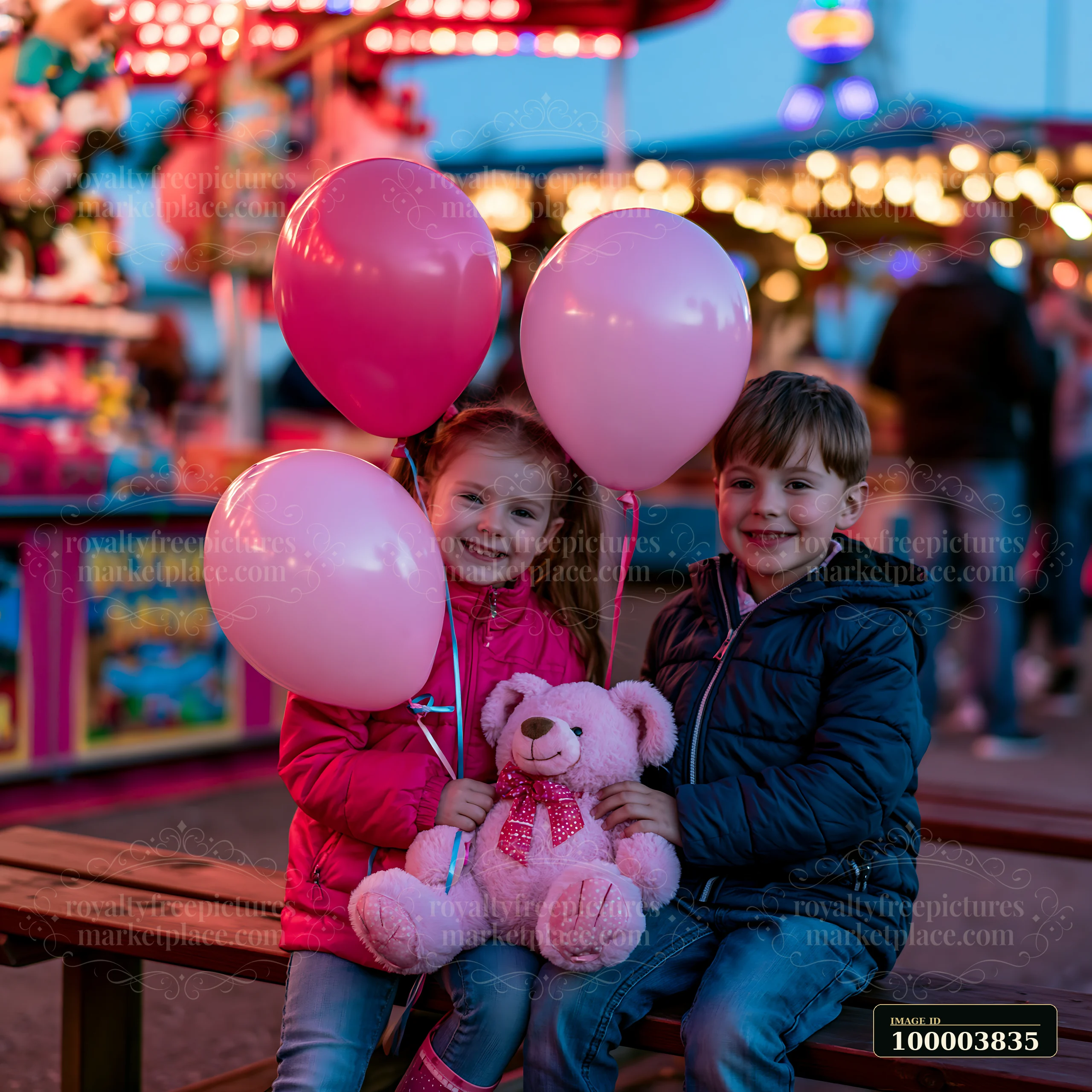 Two siblings sit on a bench at a fairground holding pink balloons and a teddy bear.