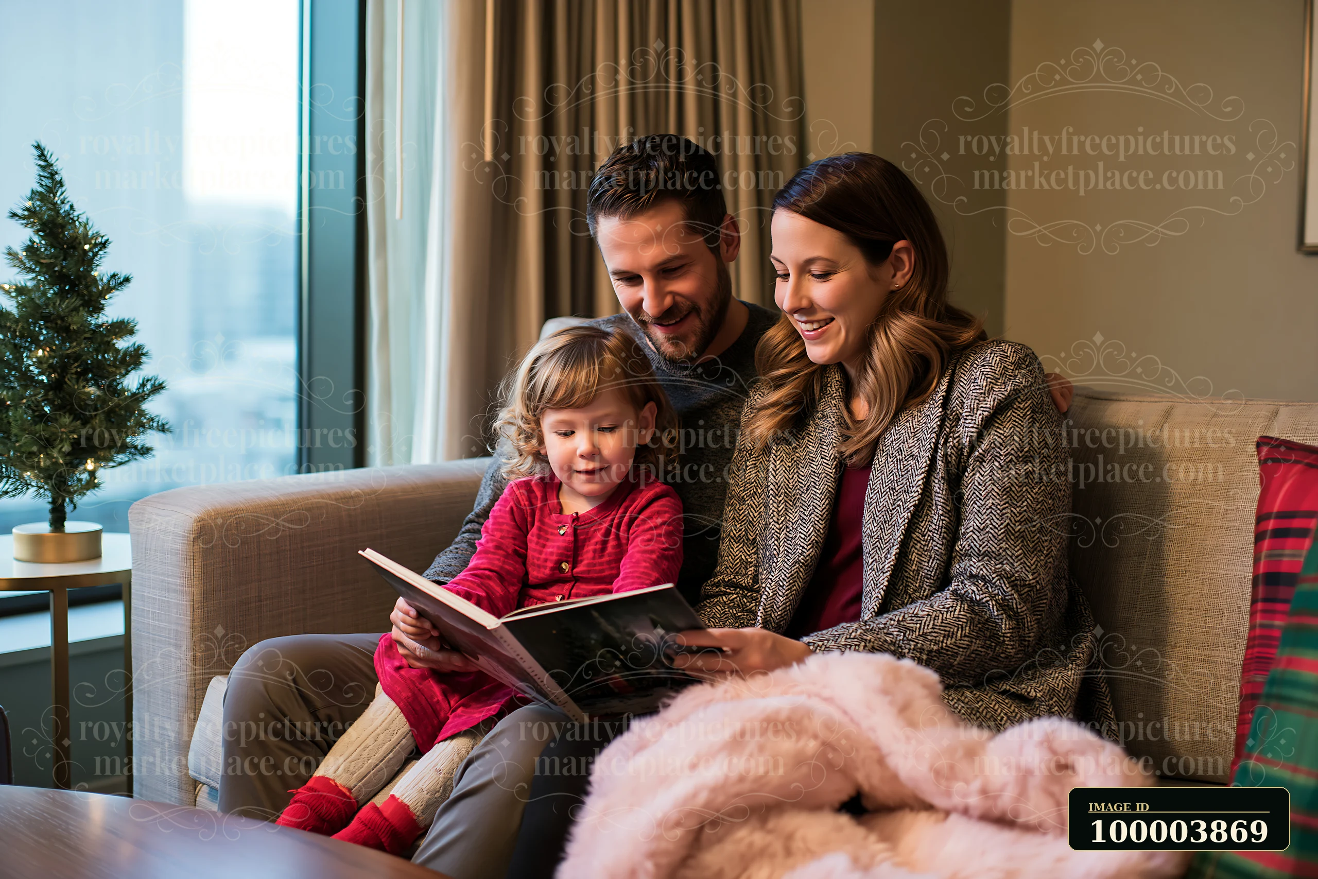 A family enjoys reading a children's book while sitting on a sofa in a warm living room.