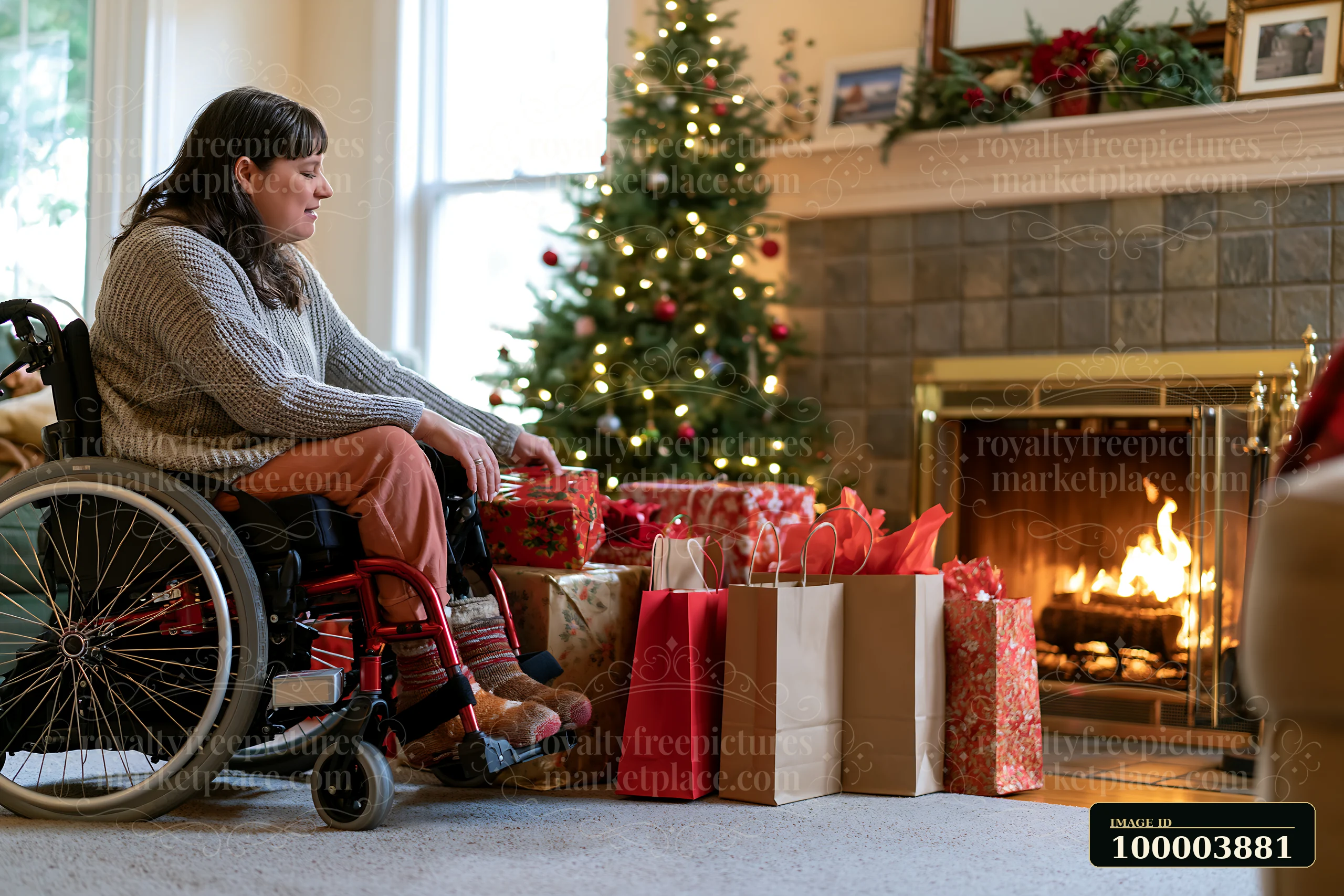 Woman in a wheelchair sits beside holiday shopping bags, wrapped gifts, a Christmas tree, and a lit fireplace.