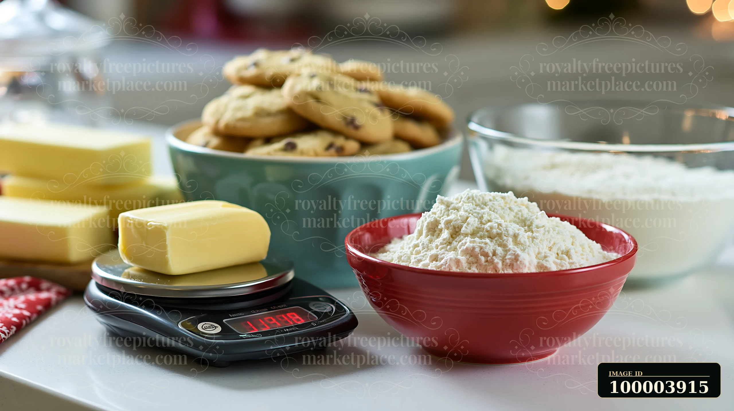 Flour, butter, cookies, a bowl, and a digital scale arranged on a kitchen counter.
