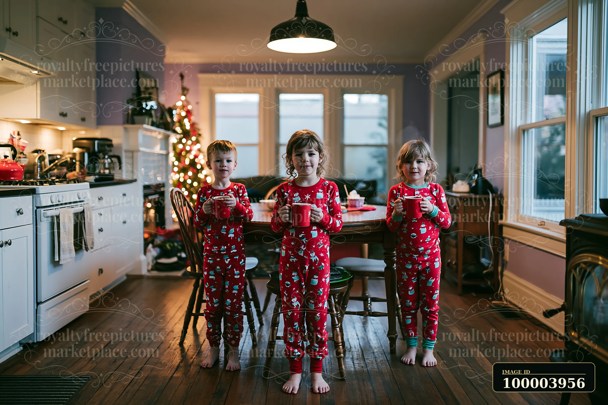 Children wearing matching pajamas Christmas morning stand by a table holding mugs.