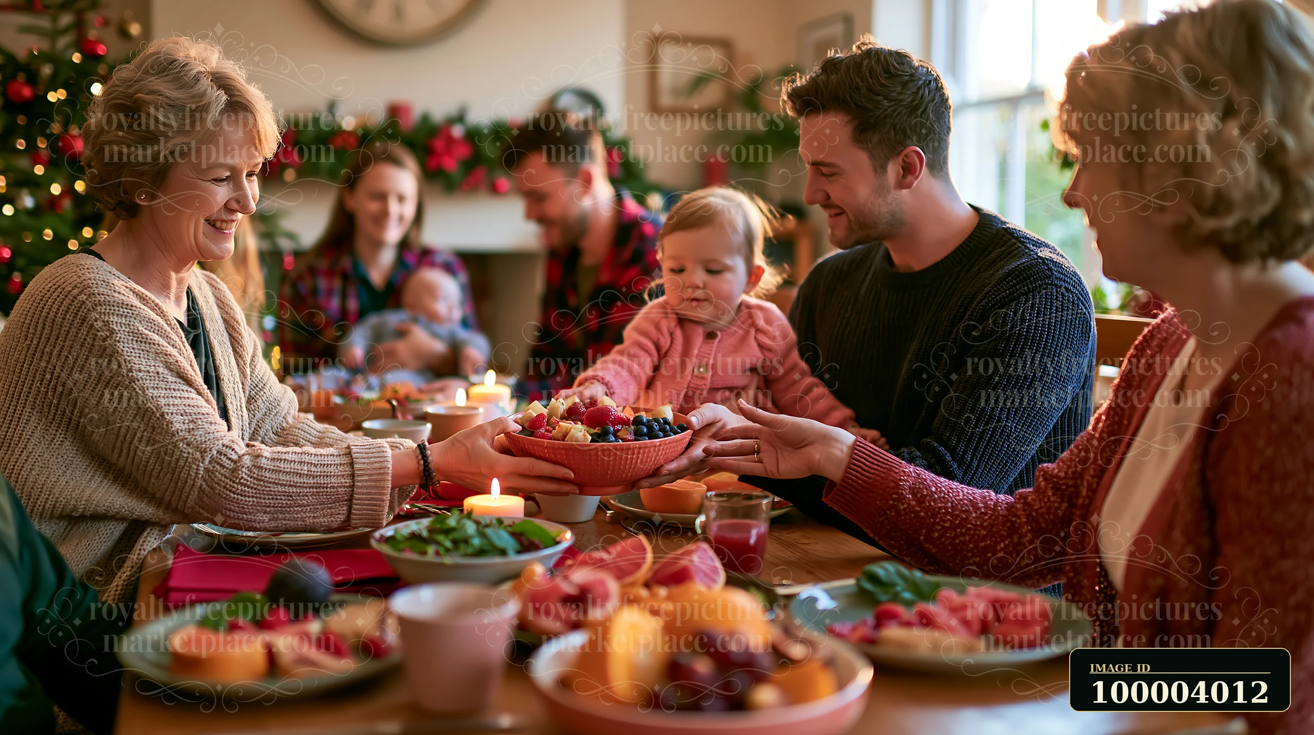 Family shares a bowl of fruit around a festive Christmas breakfast table.