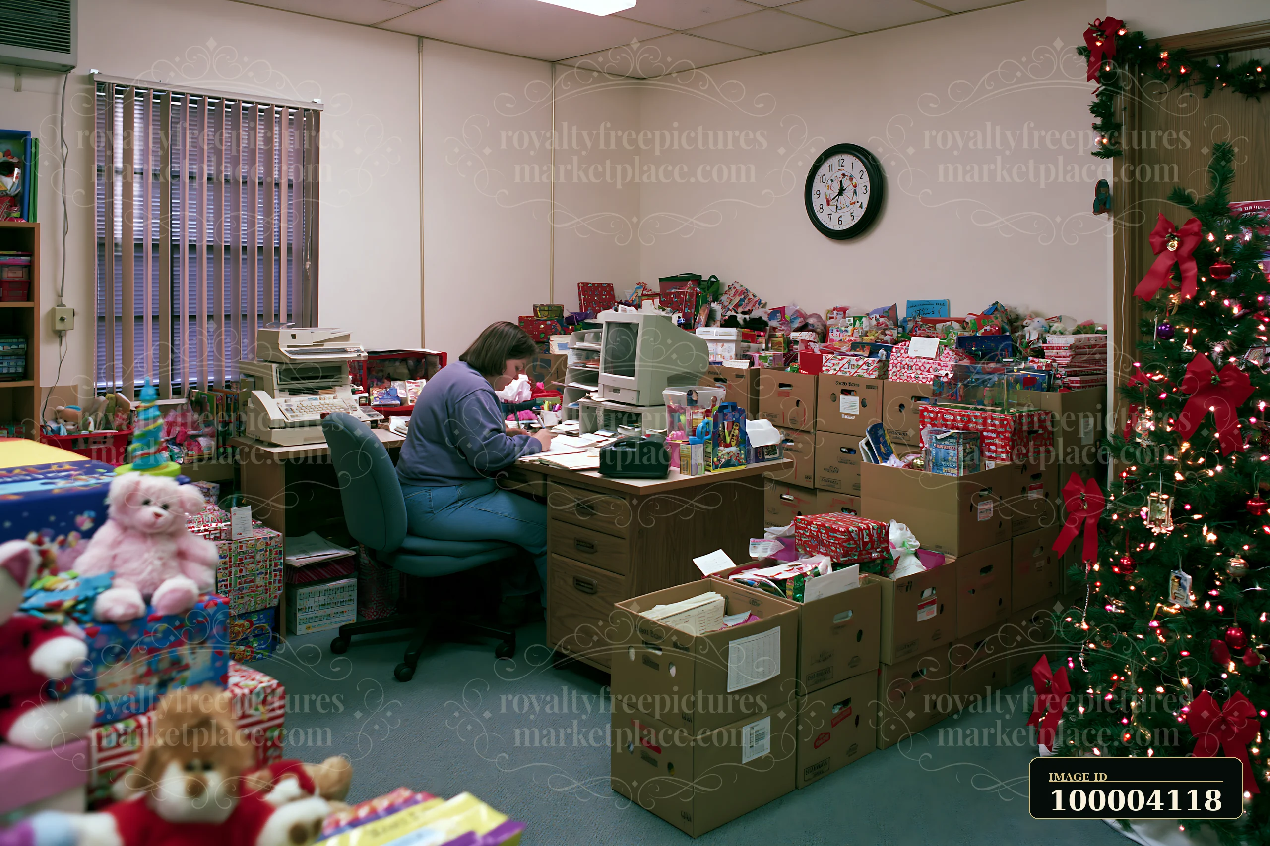 A person sits at a desk in a holiday-themed office, writing a gift list.