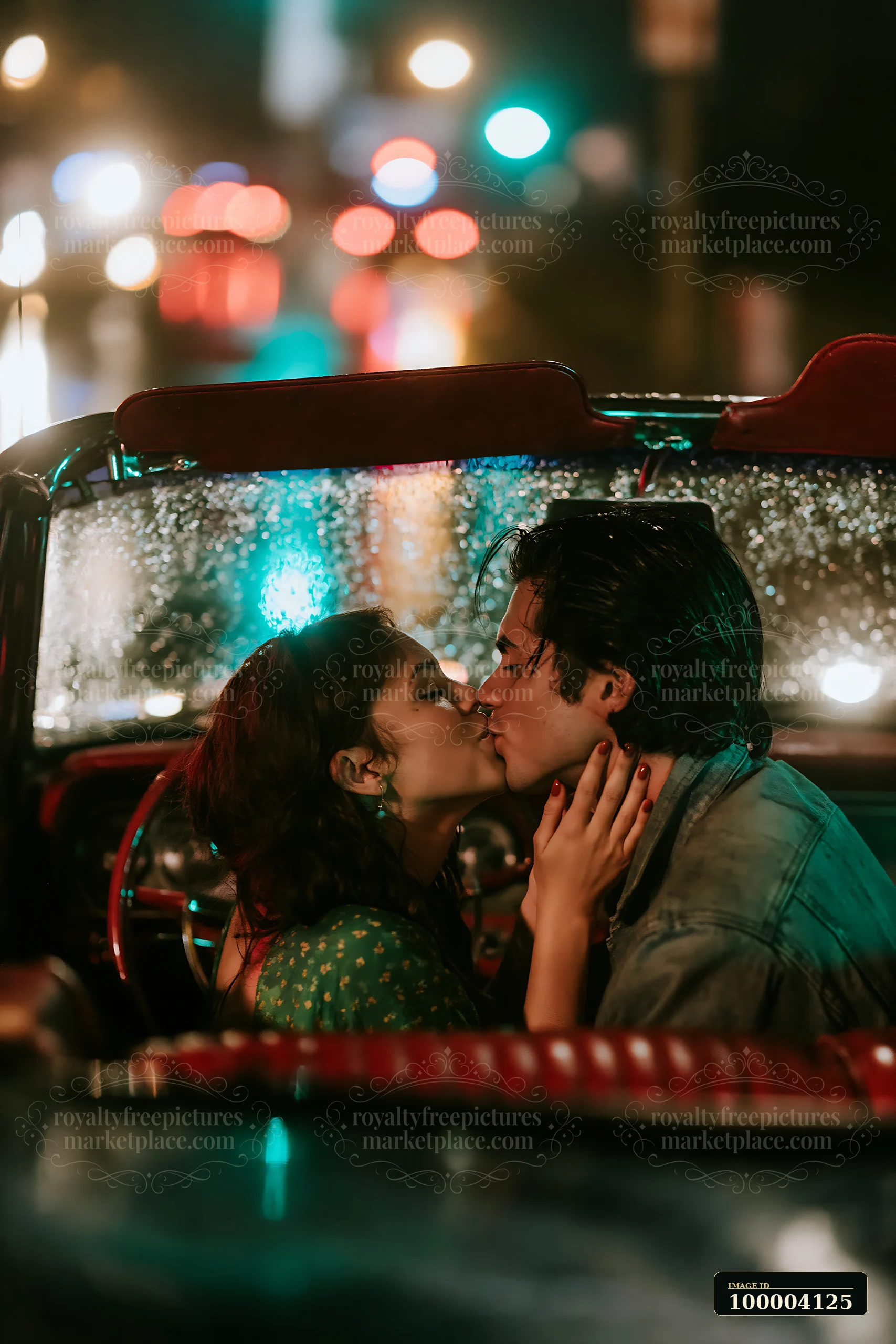 A couple is kissing inside a vintage car while raindrops cover the windows.