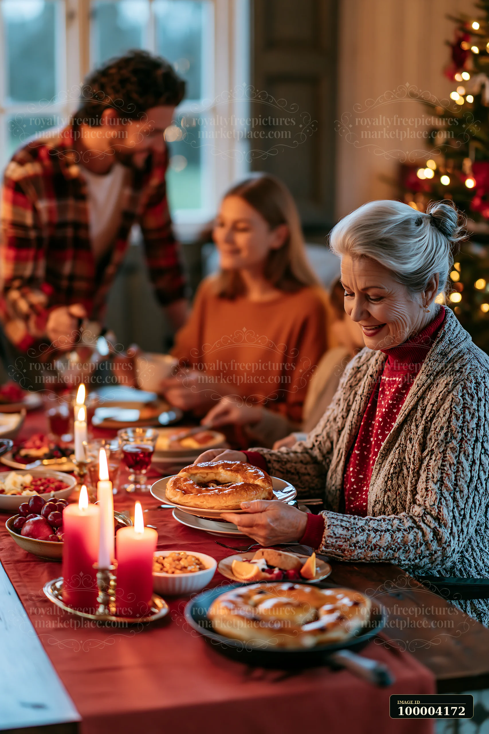Family shares a festive breakfast around a candlelit table beside a decorated Christmas tree.