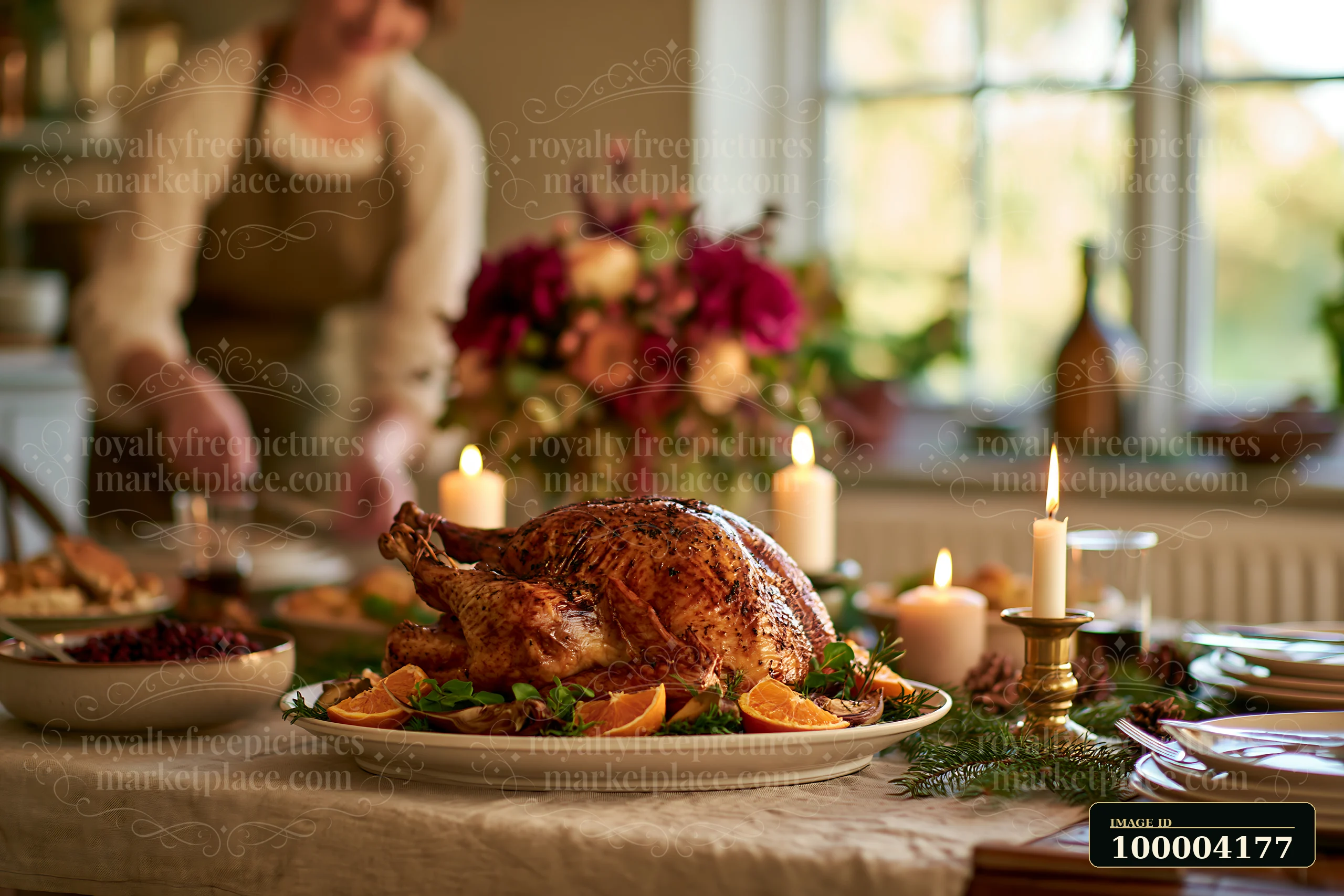 Roasted turkey on festive dining table surrounded by food, candles, and flowers.