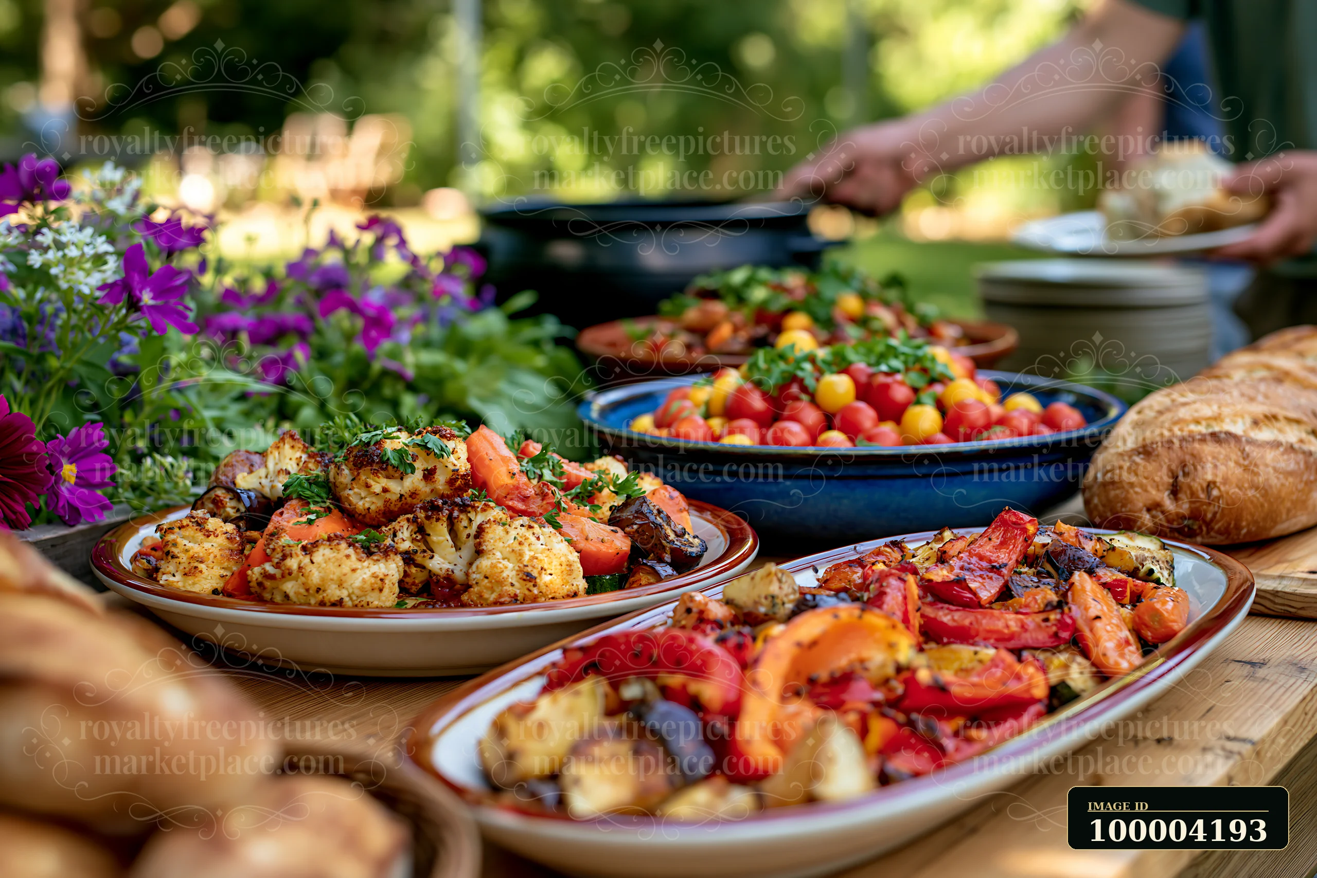A vegetarian buffet displays roasted vegetables and fresh bread in a garden setting.