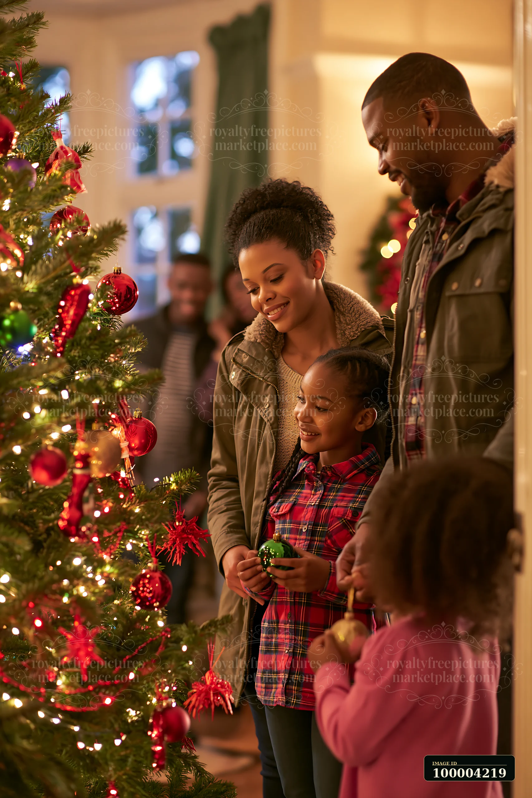 Family is decorating a Christmas tree indoors, adding ornaments and lights in a festive living room setting.