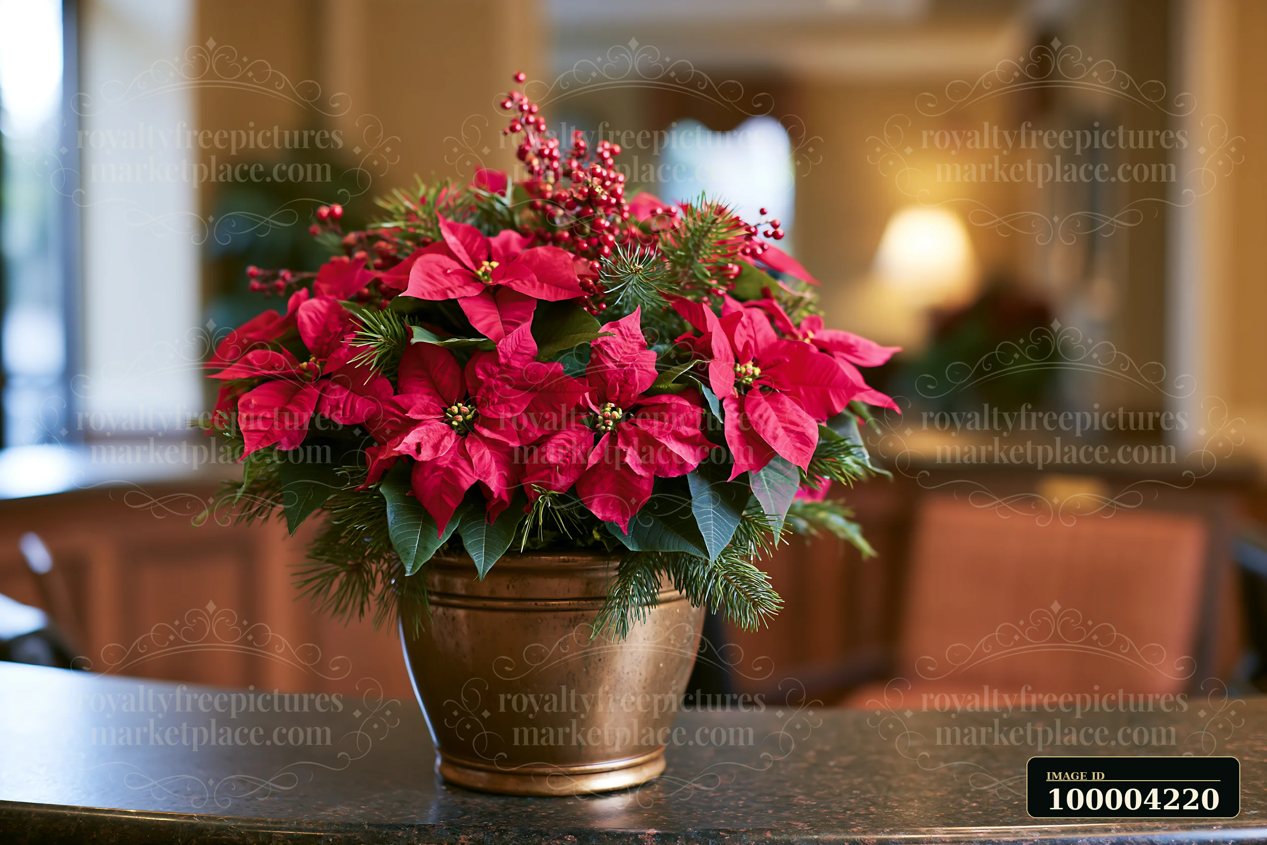 Red poinsettias, evergreen branches, and berries form a Christmas arrangement in a ceramic pot on a countertop.