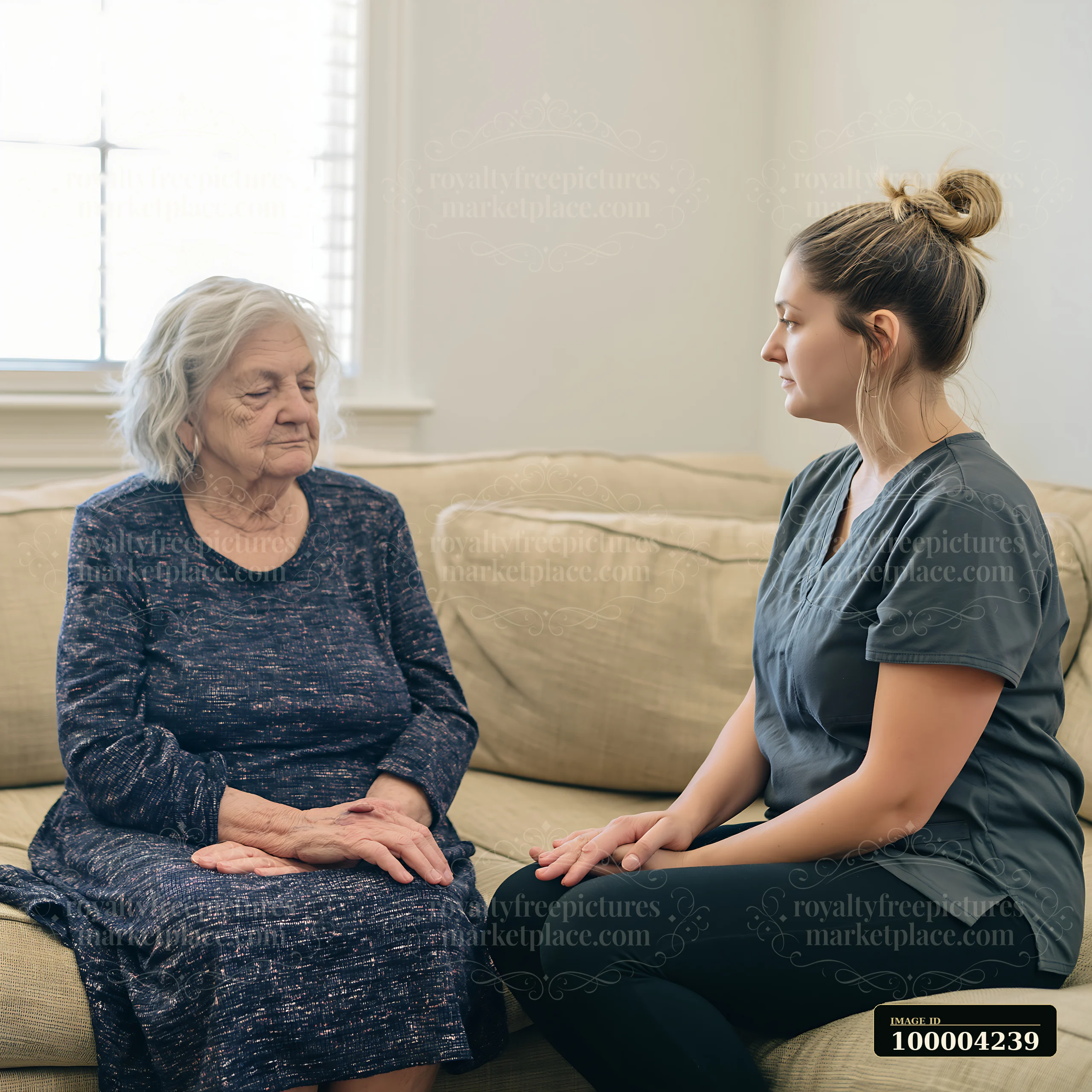 Caregiver sits beside an elderly patient on a sofa in a bright home interior, offering comfort and companionship.