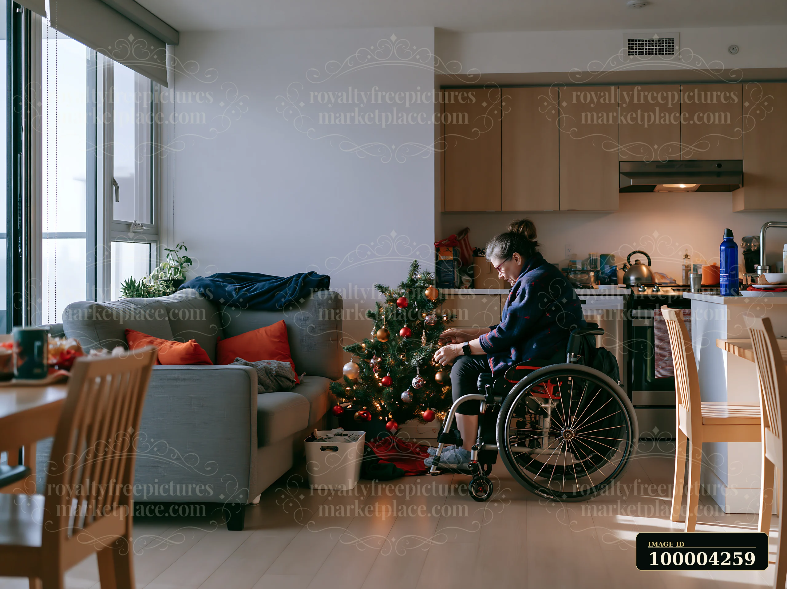 A person in a wheelchair is decorating a small apartment for the holidays.