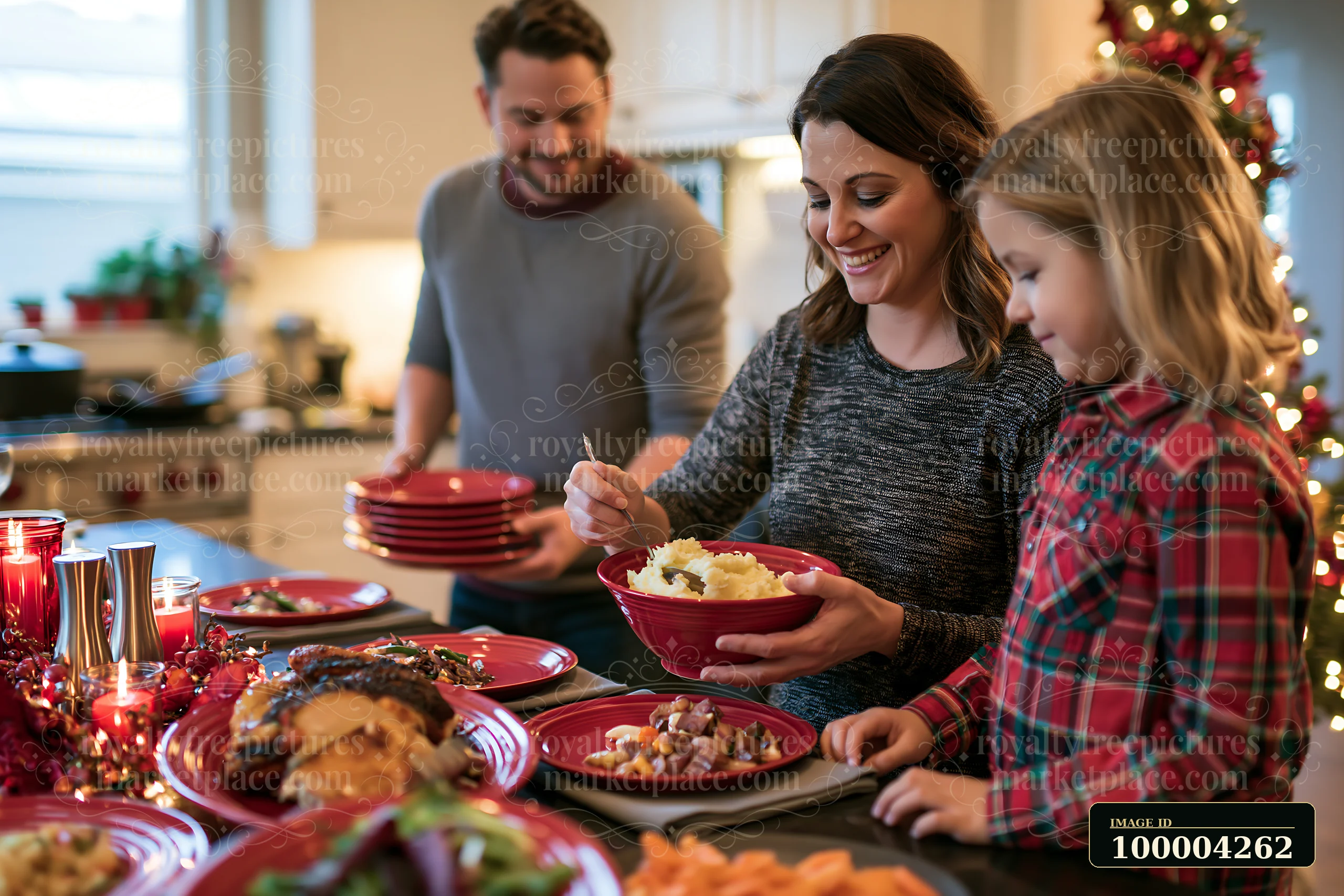 Parents serve mashed potatoes while a child helps at a Christmas dinner table beside a decorated tree.