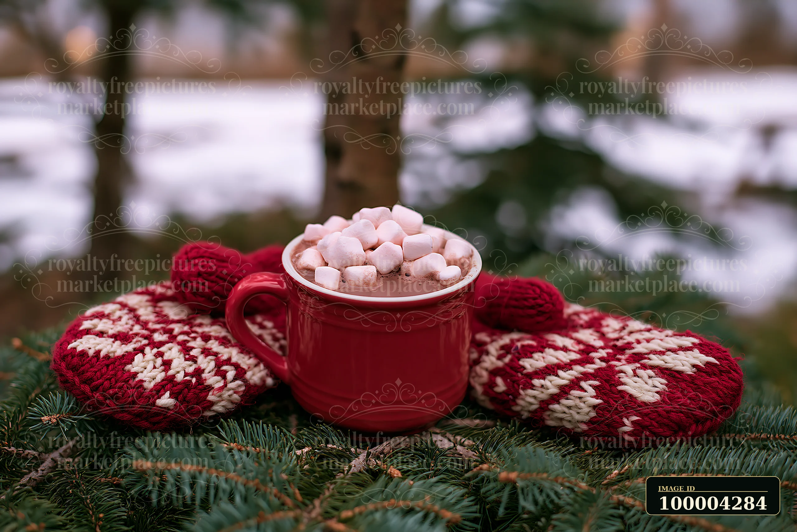 A red mug filled with warm cocoa topped with marshmallows rests on a snowy tree branch surrounded by knit mittens.