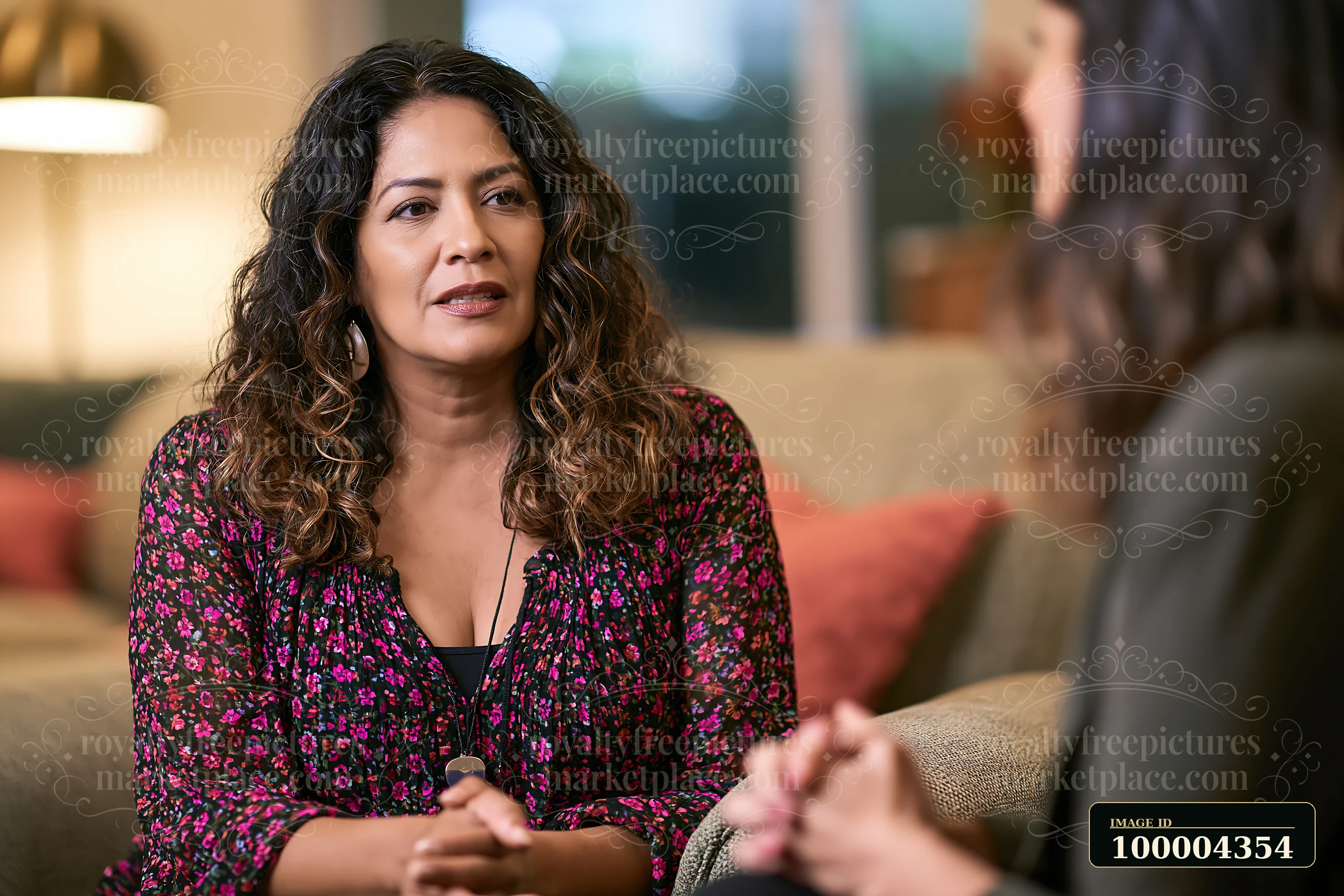 Therapist listens attentively to a person seated in a warmly lit counseling setting.
