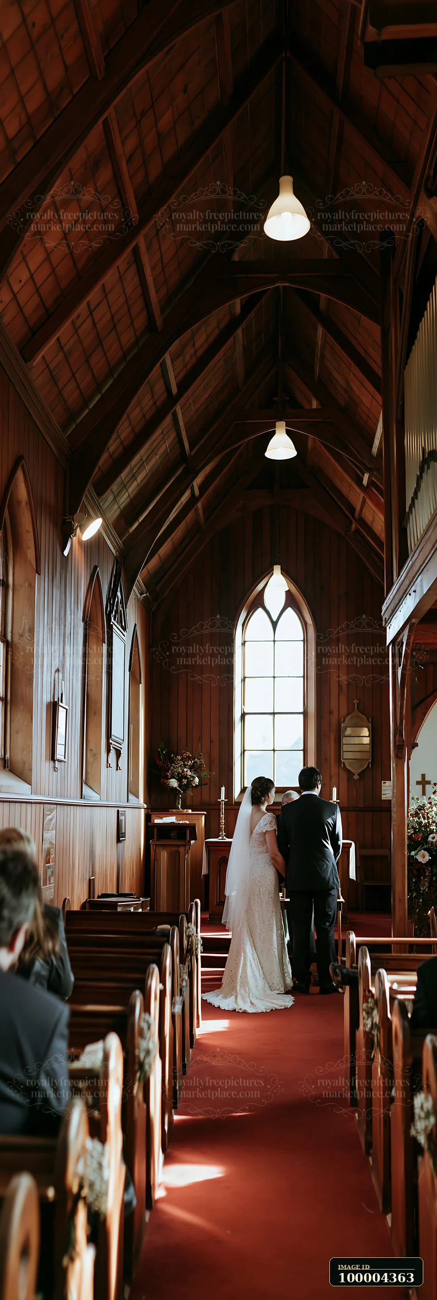Bride and groom stand at the altar during a ceremony inside a warmly lit wooden chapel.