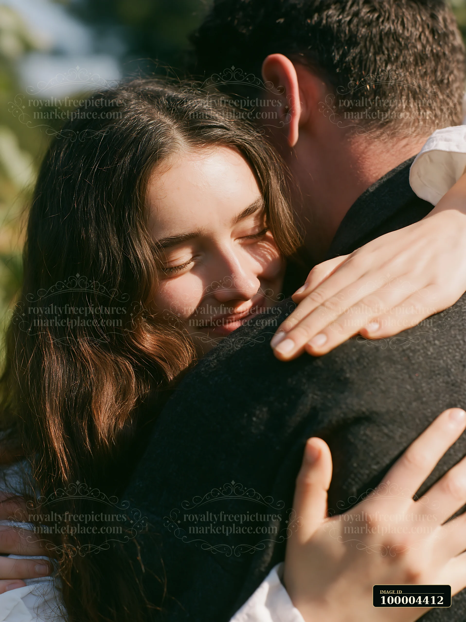 A couple embraces outdoors surrounded by nature in spring sunlight.