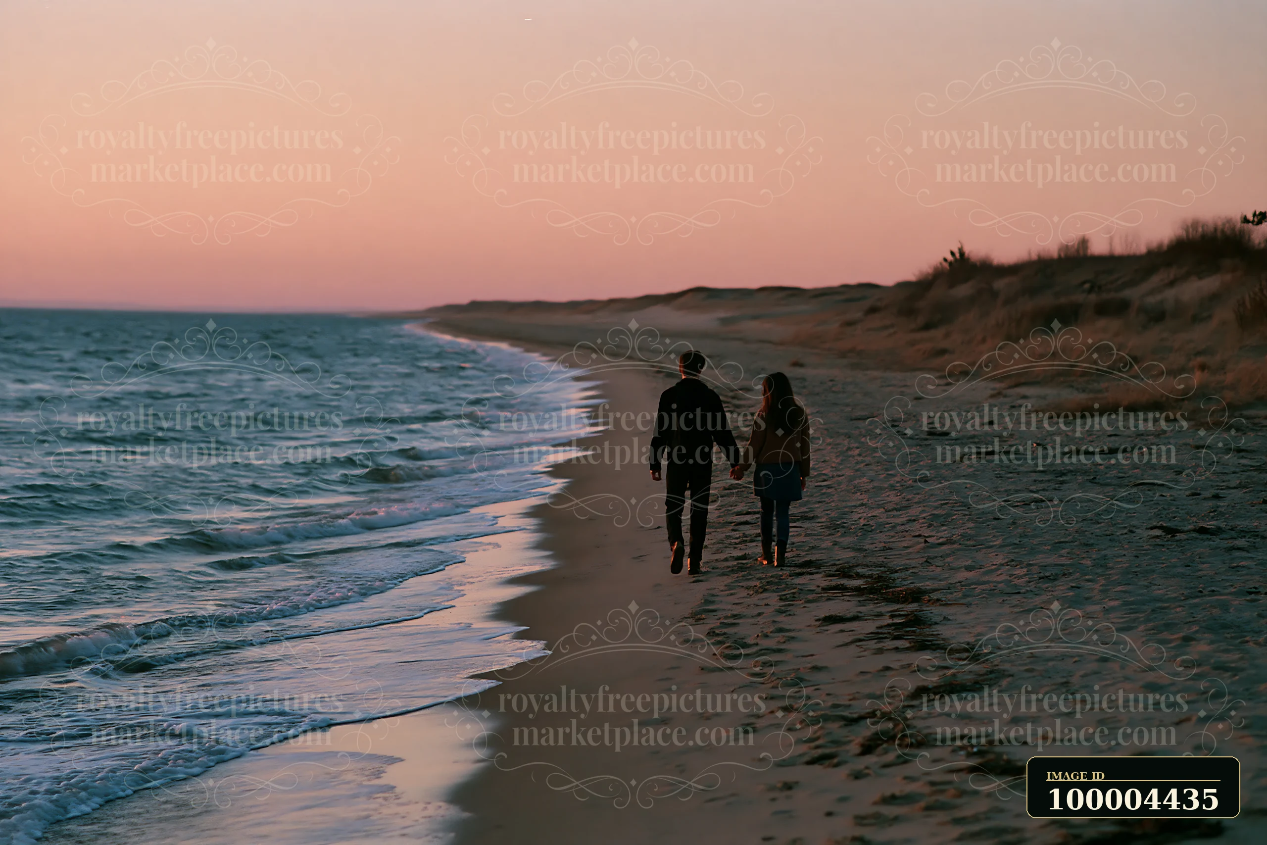 A couple walks hand in hand along the shore at dusk.