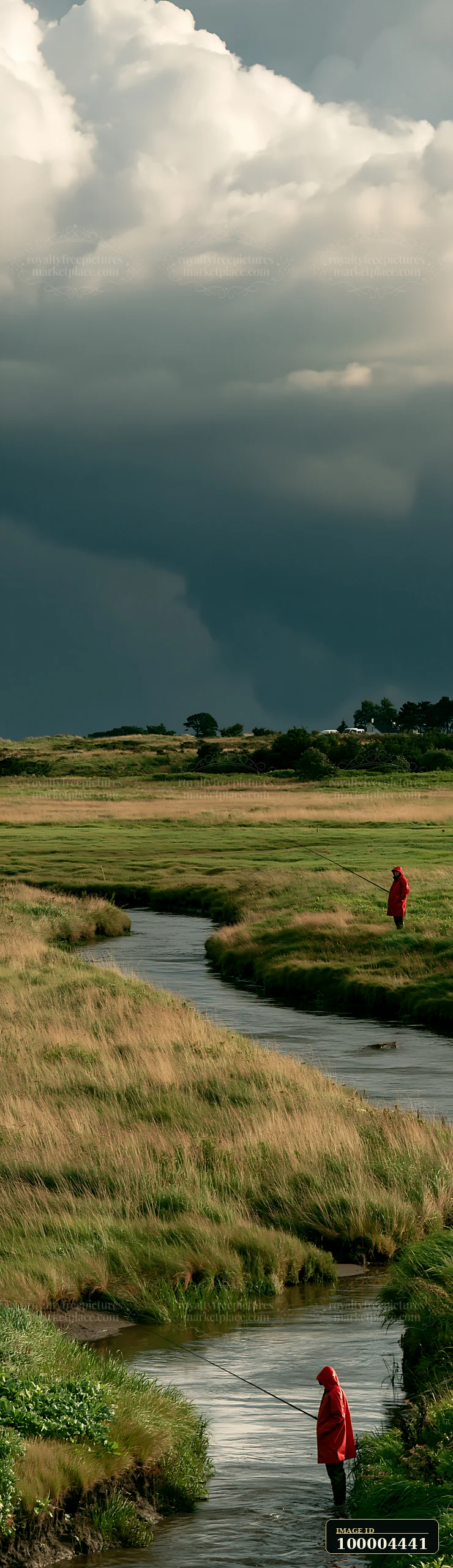 Two people fish in a winding stream across a seaside meadow beneath dramatic storm clouds.