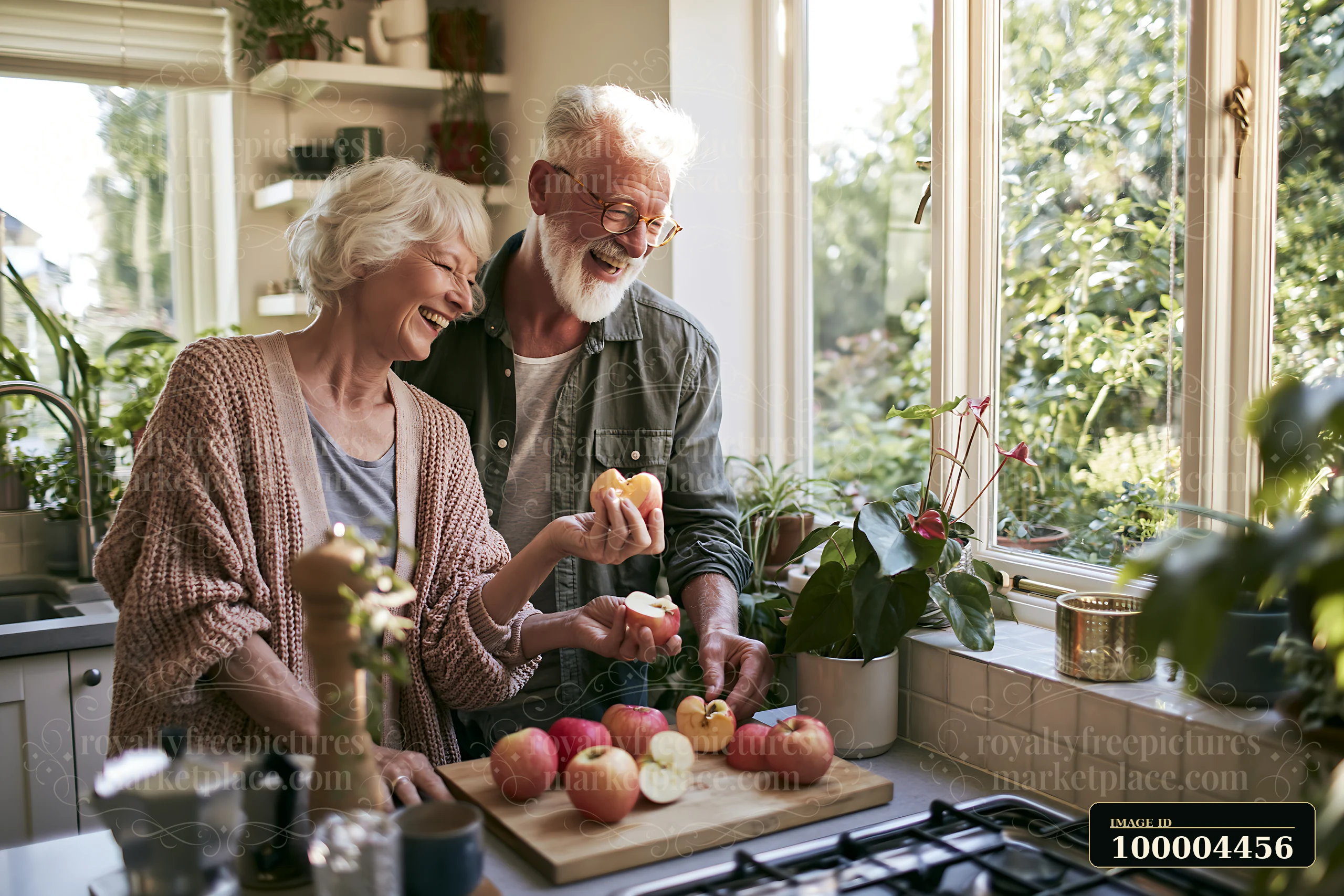 An elderly couple laughs together while preparing apples at a kitchen counter filled with plants.