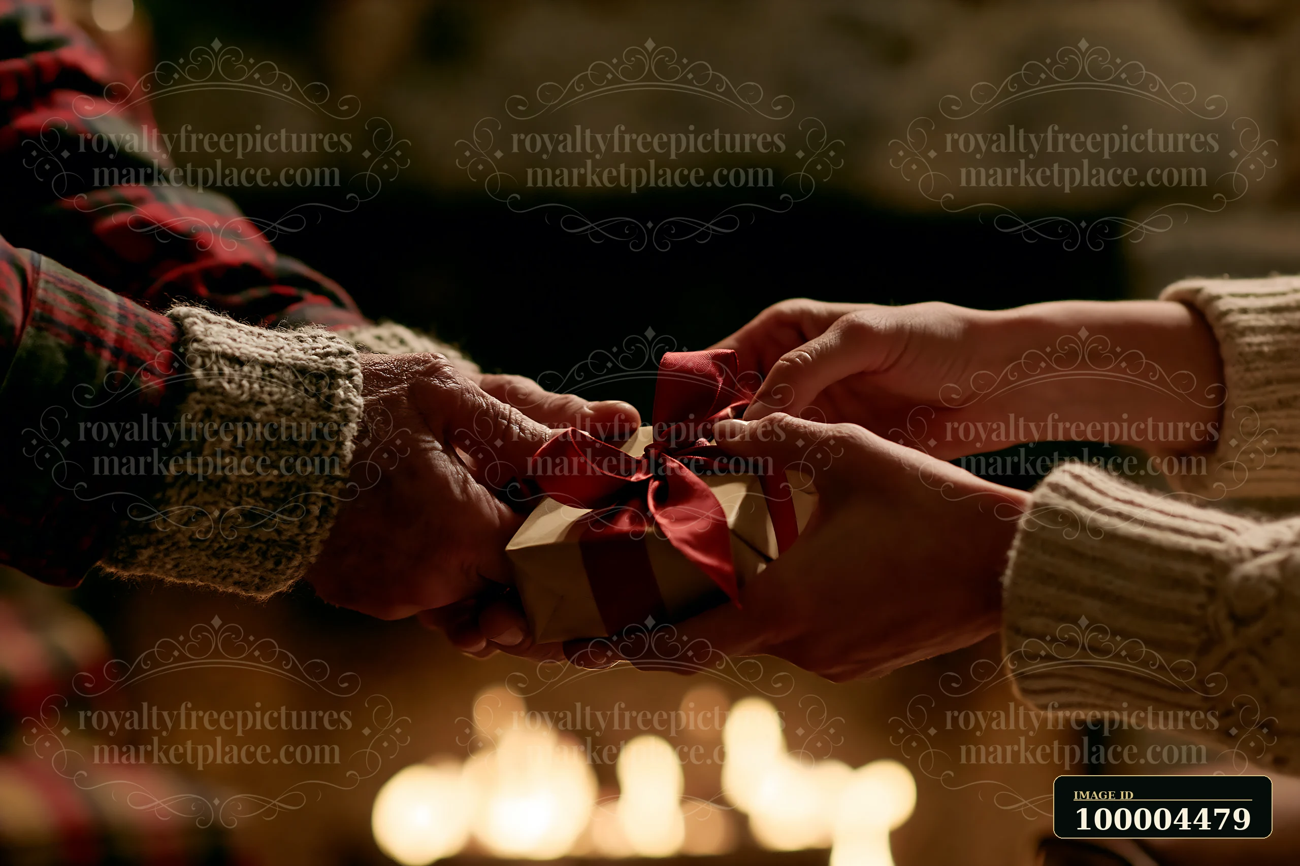 Two pairs of hands exchange a wrapped gift with a red ribbon in warm candlelight.